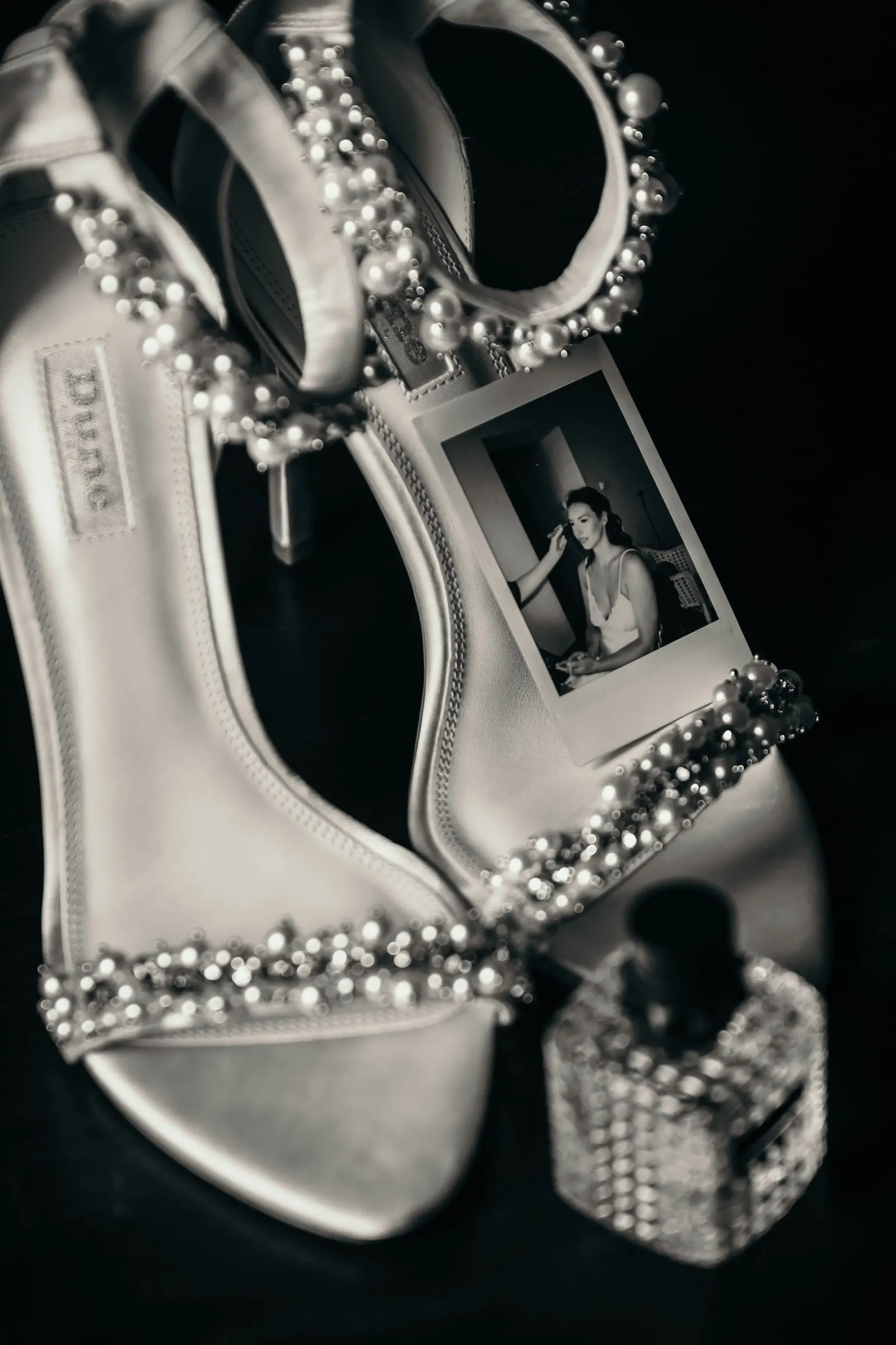 Sandalias de novia con pedrería, perfume y un pequeño retrato impreso, detalle de boda en blanco y negro