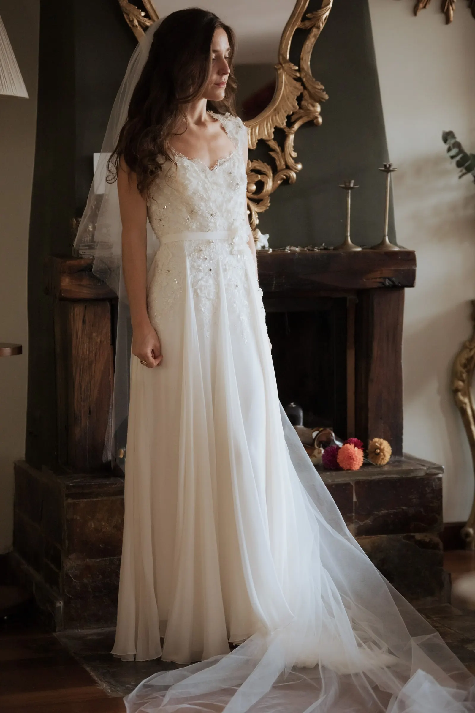 Bride in her gown and long veil by a fireplace and a gilded mirror, Barbillón, Marbella