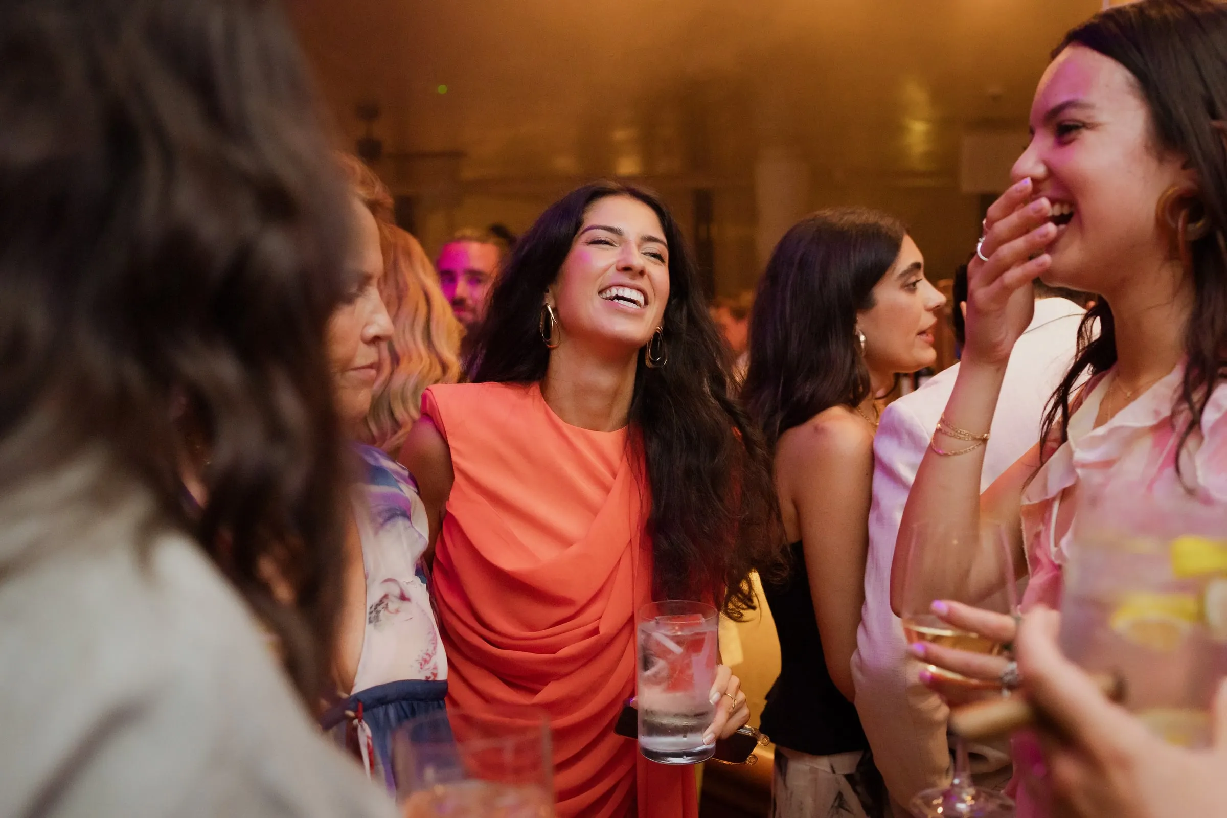 Guest in an orange dress laughing with friends at the party, Barbillón, Marbella