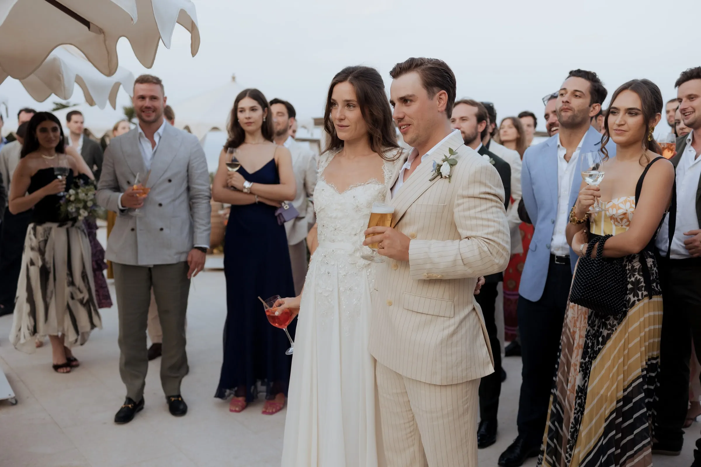 Bride and groom with drinks among their guests at the cocktail hour at Barbillón, Marbella