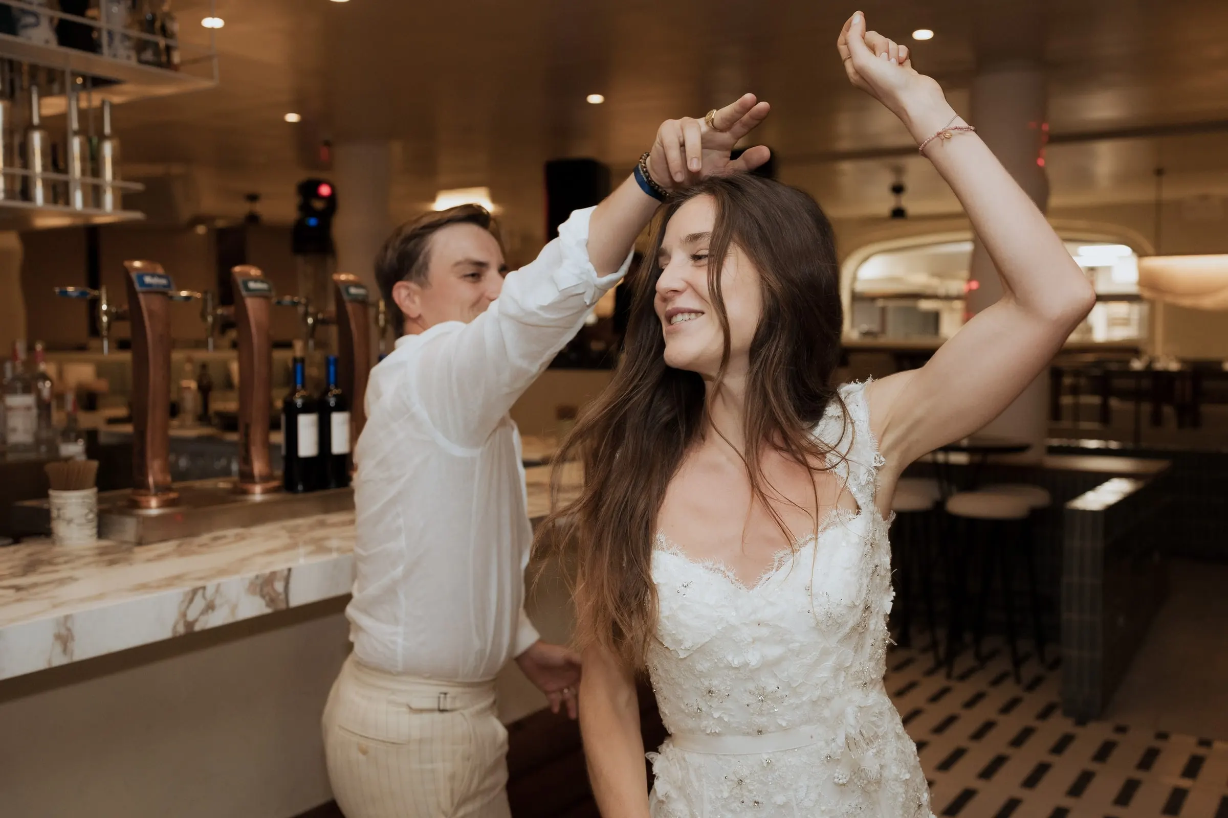 Groom twirling the bride on the dance floor by the bar at Barbillón, Marbella