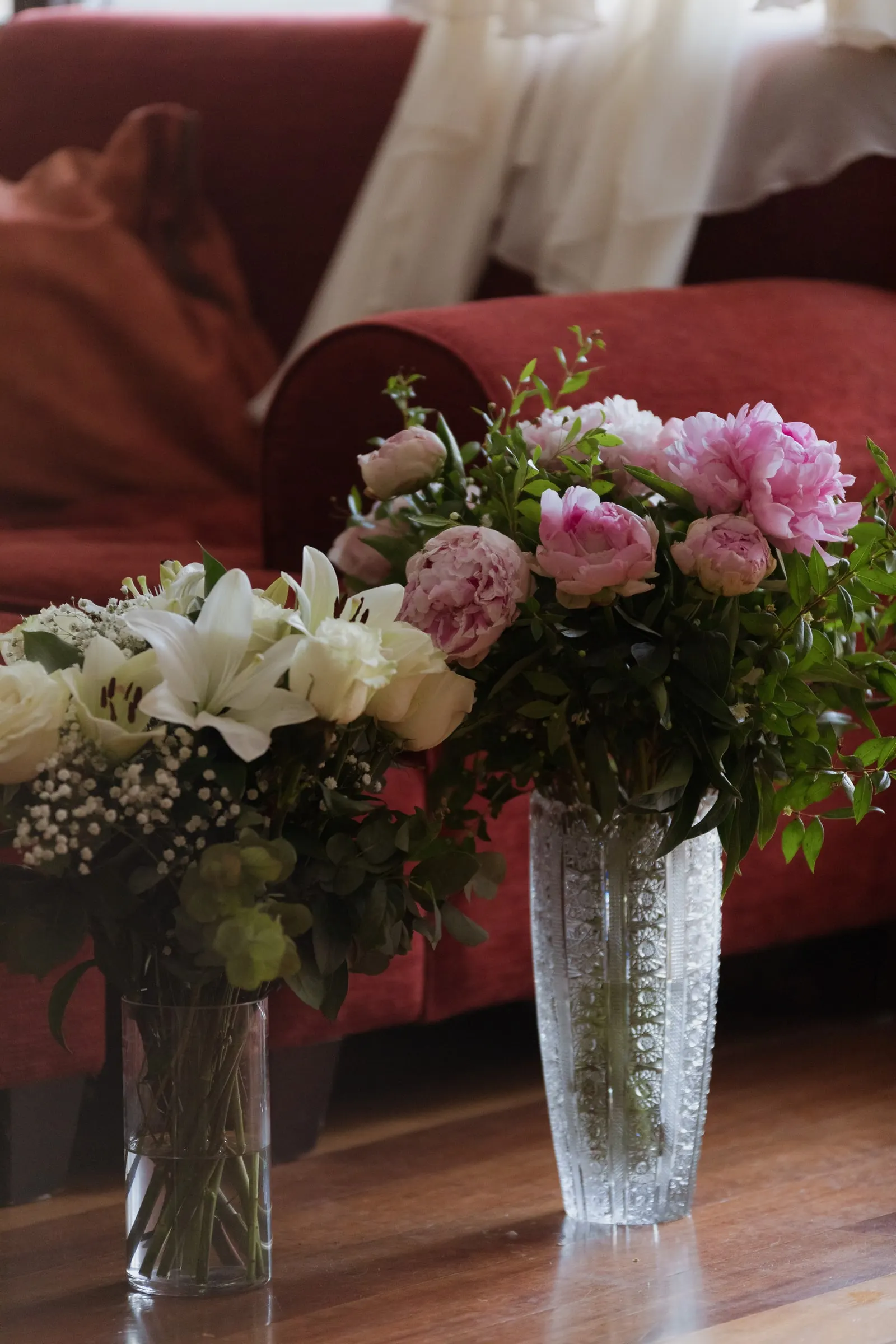 Peonies and lilies in crystal vases in front of a red sofa, Barbillón, Marbella