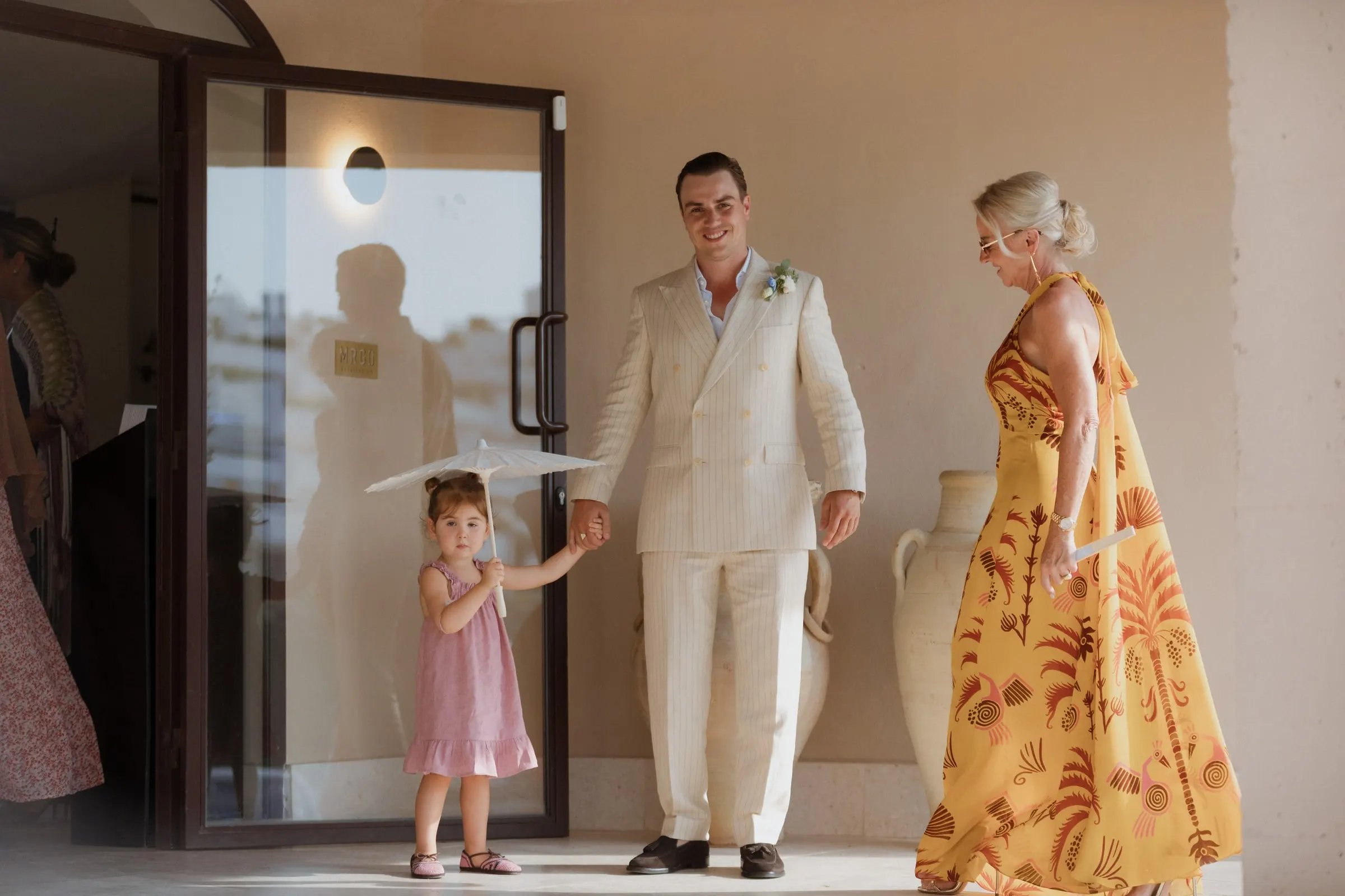 Groom holding hands with a little girl carrying a white parasol, Barbillón, Marbella
