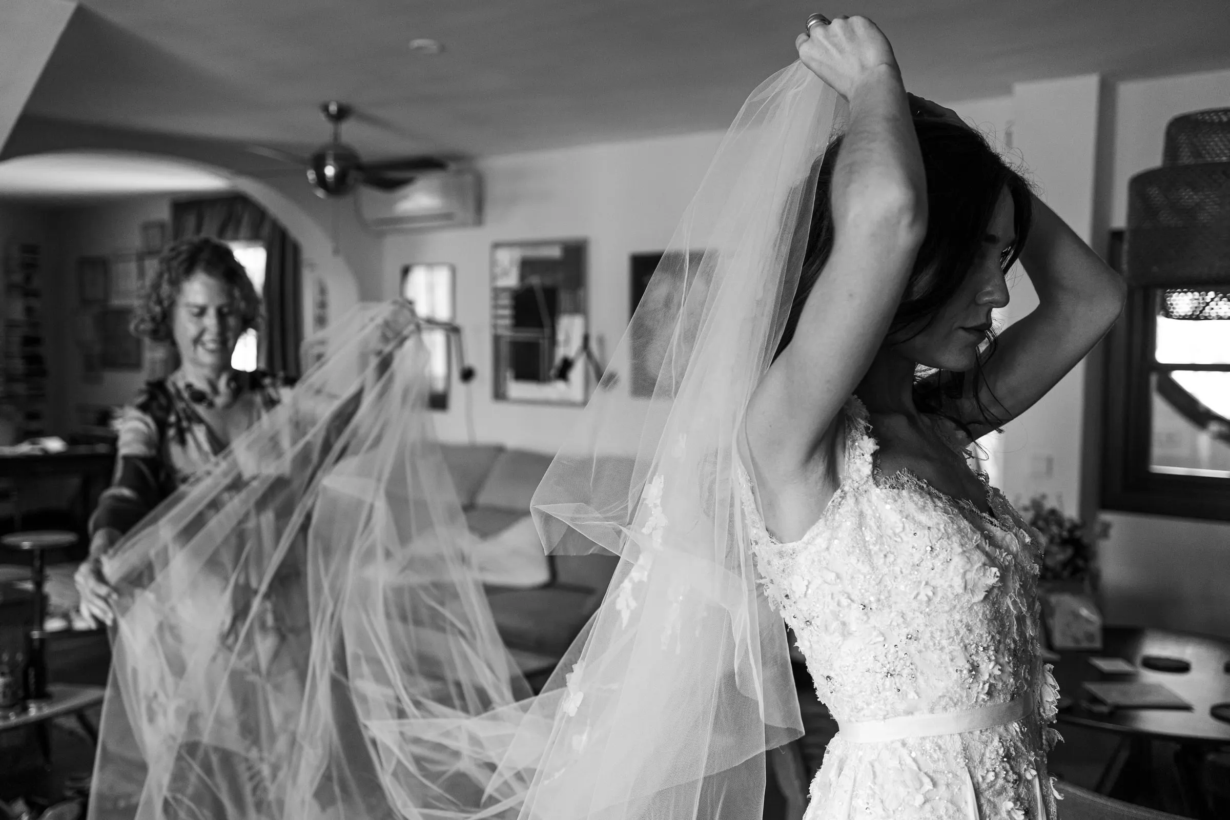 Black and white of the bride lifting her veil as a woman helps her, Barbillón, Marbella