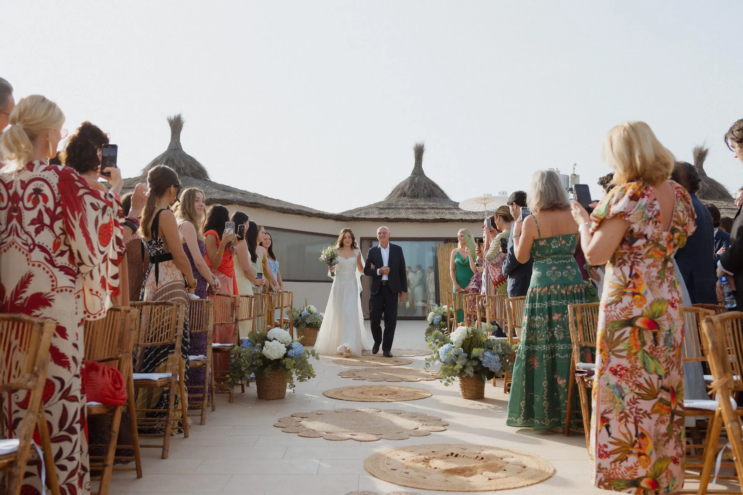 Bride walking down the aisle on her father's arm as guests take photos, Barbillón, Marbella