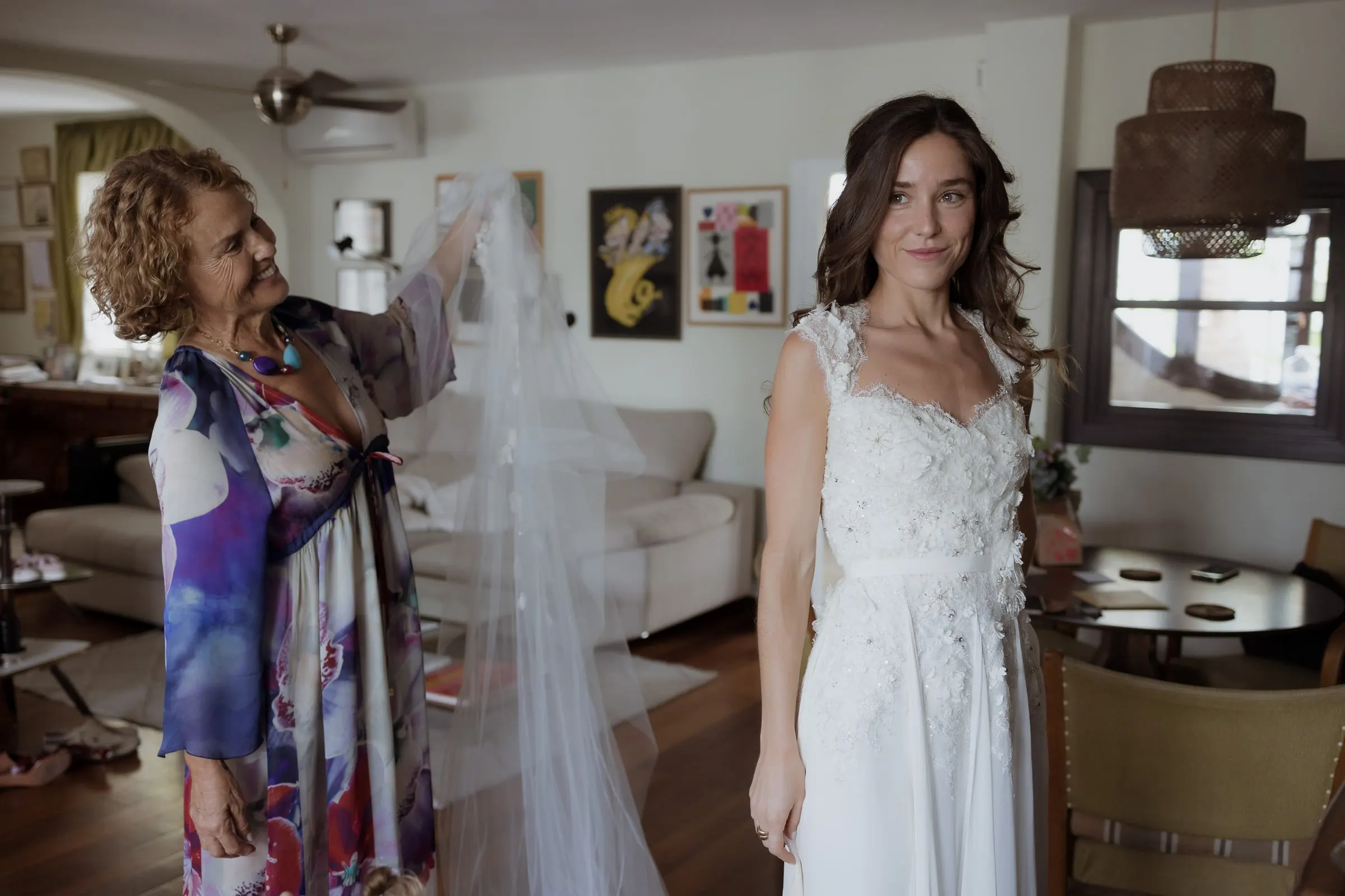 Woman holding up the long veil as the bride smiles in her gown, Barbillón, Marbella