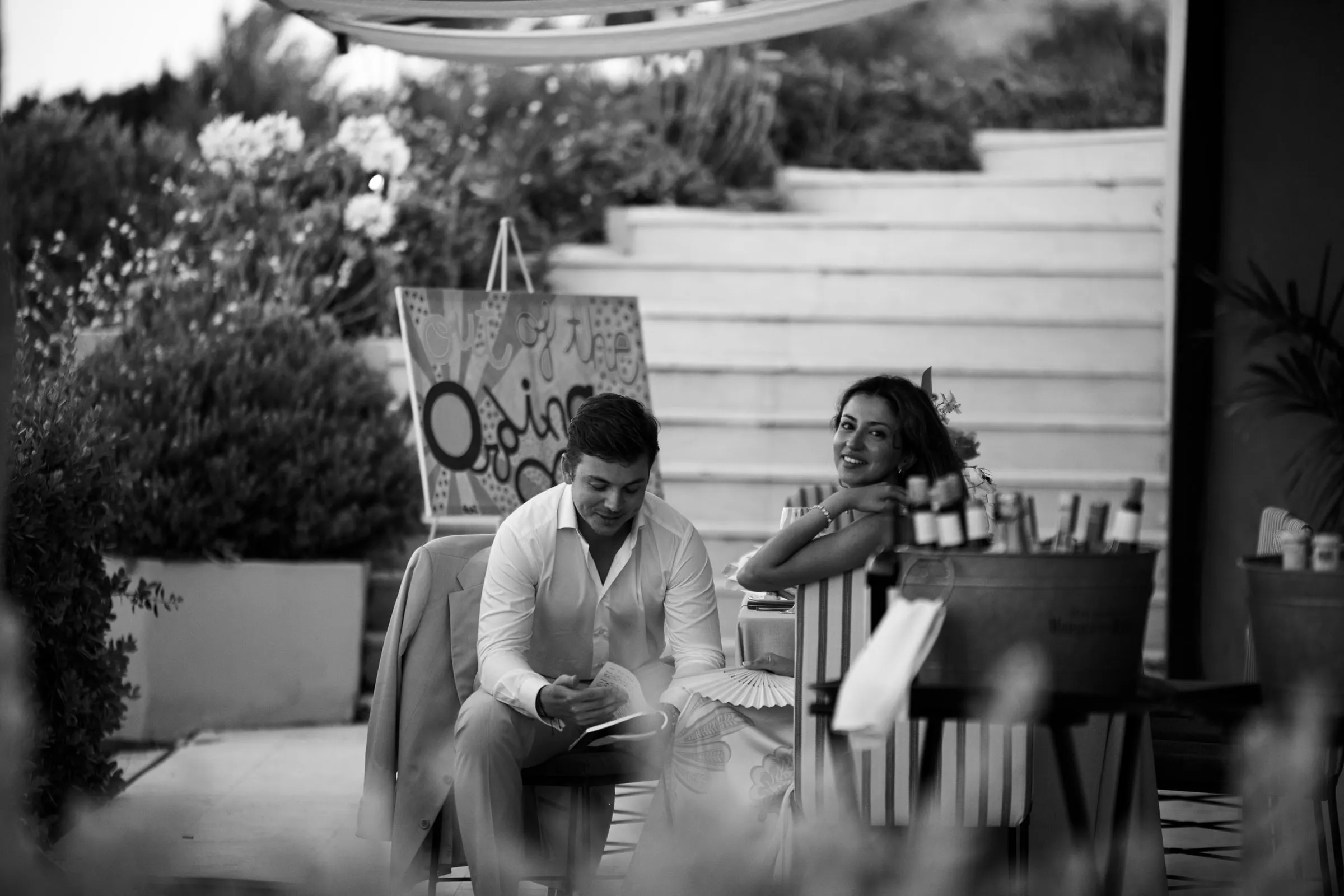 Black and white of two guests relaxing, one reading and one smiling, Barbillón, Marbella
