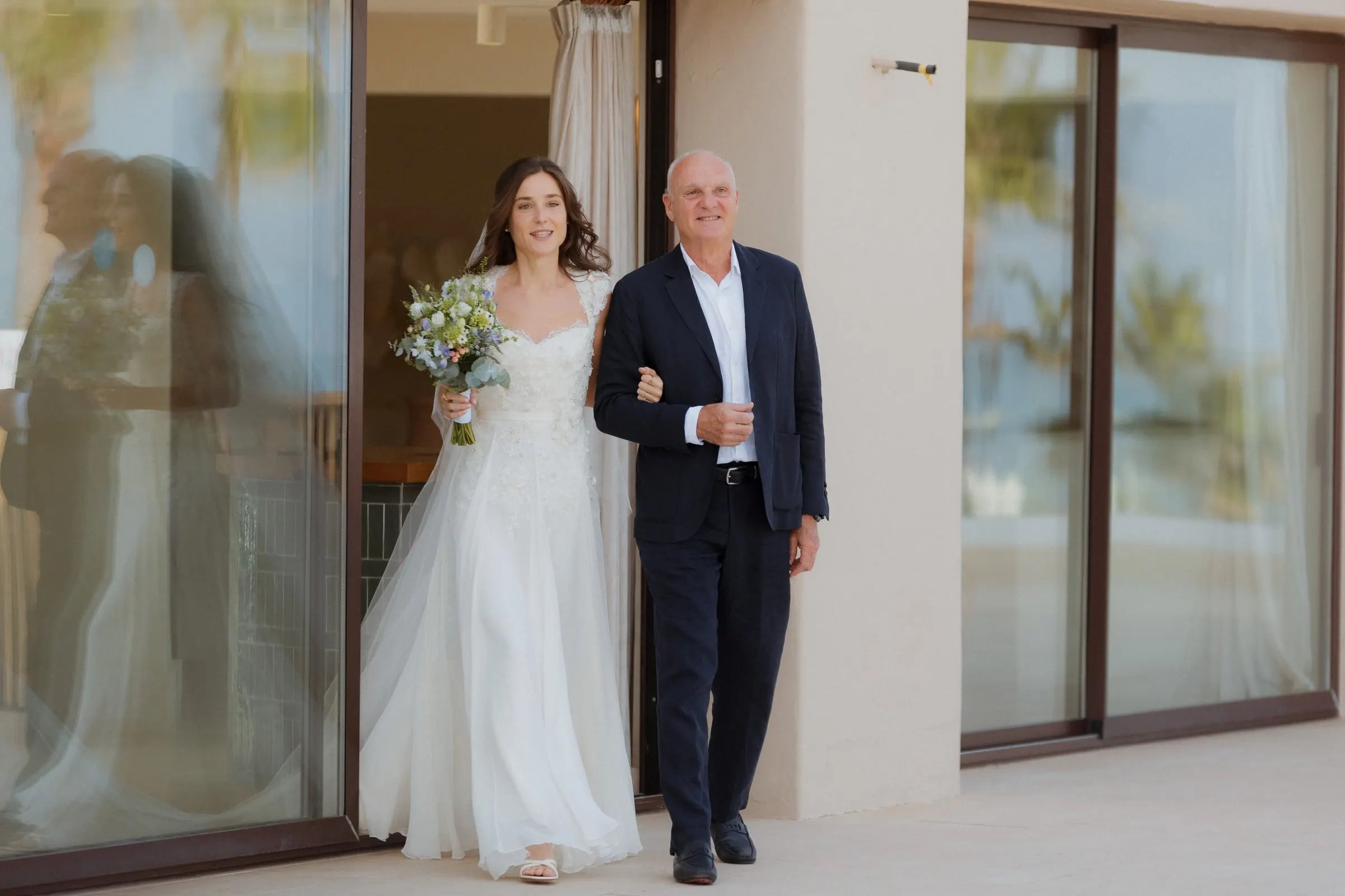 Bride on her father's arm stepping out of the villa towards the ceremony, Barbillón, Marbella