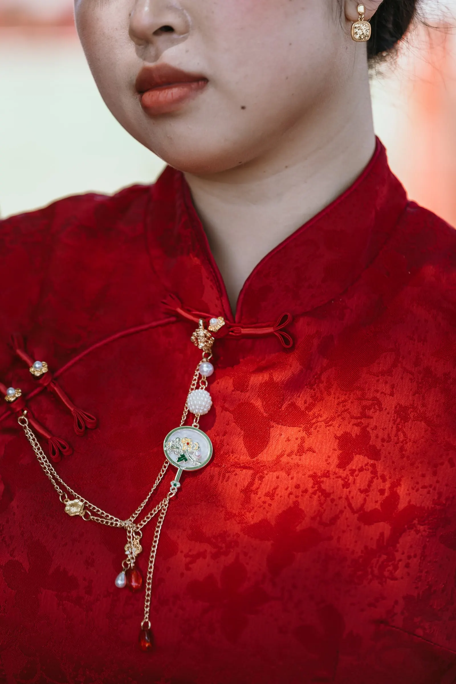 Close-up of the high collar of her red qipao and its pendant, pre-wedding session in Alhaurín de la Torre