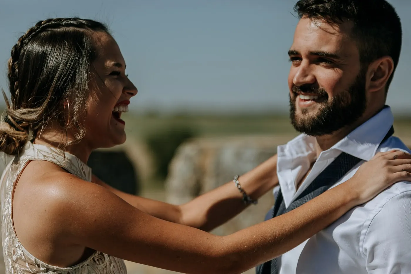 Friend laughing as she helps the groom with his shirt, Salamanca