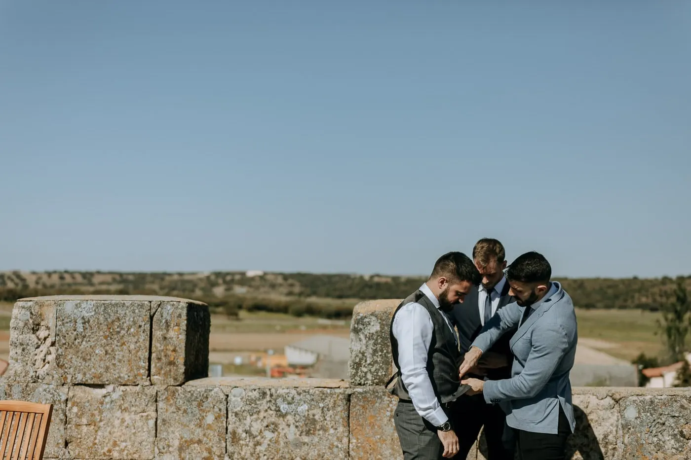 Groom and friends getting ready on the stone terrace above the fields of Salamanca