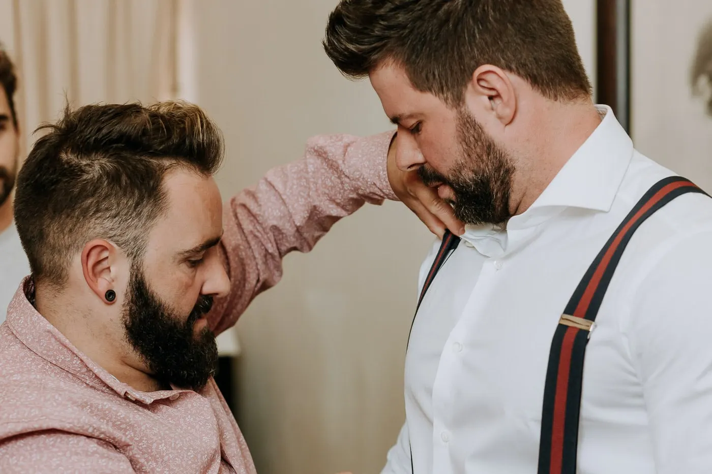 Friend fixing the groom's braces as he looks down, Salamanca