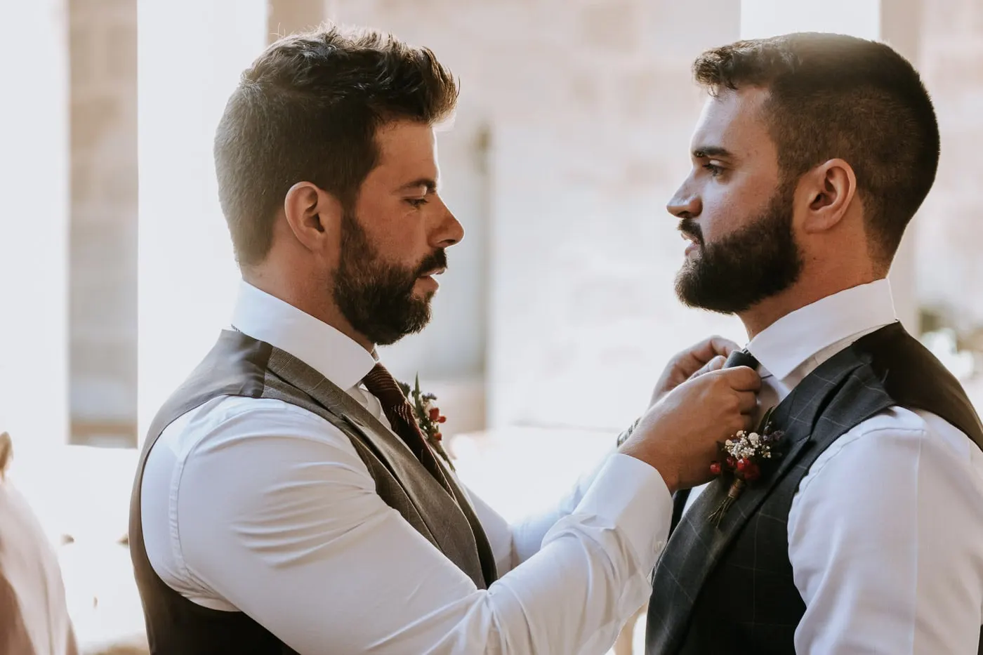 One groom straightening the other's tie on the cloister gallery, Castillo del Buen Amor