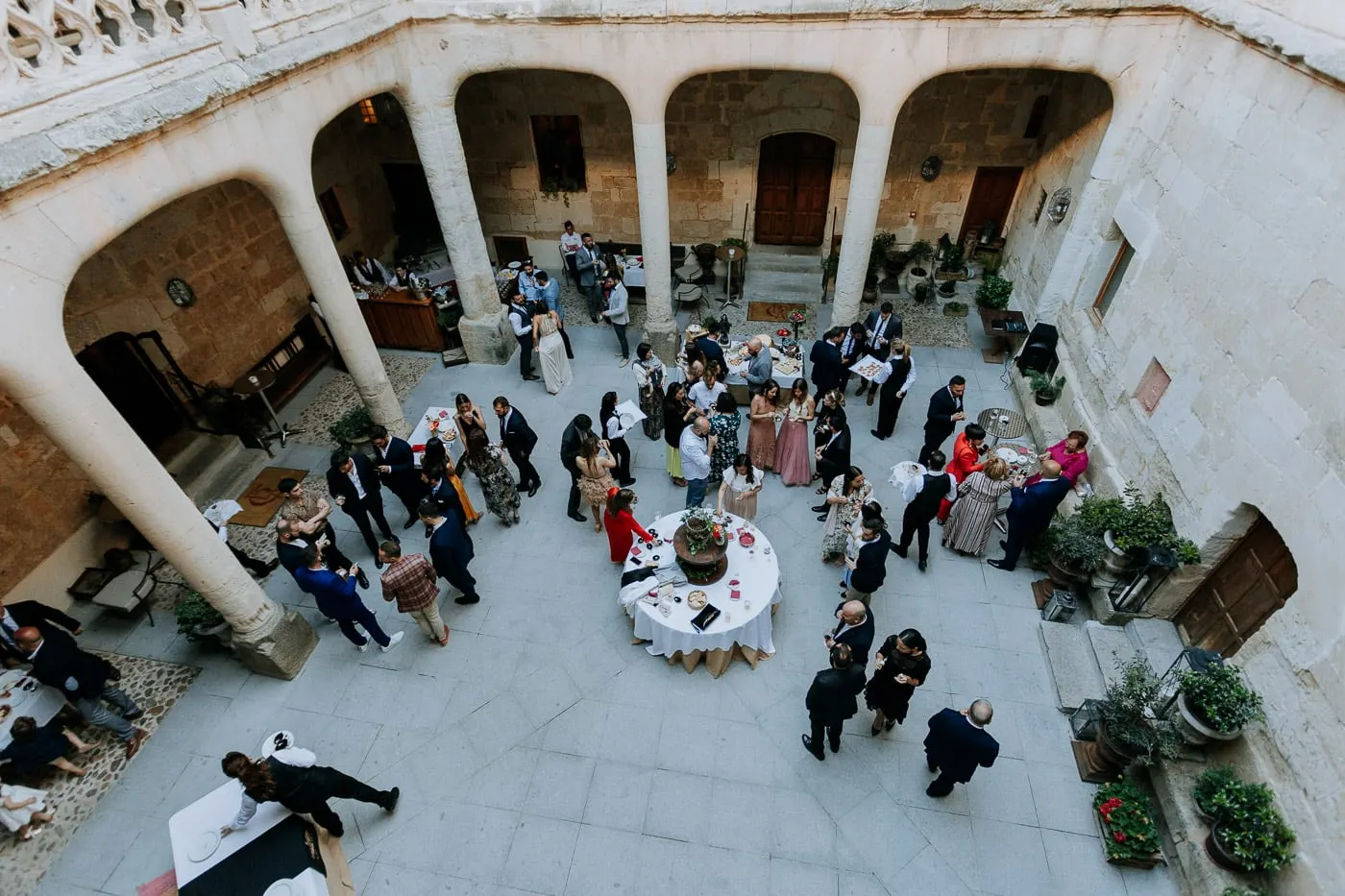 Drinks reception in the arcaded stone courtyard seen from the gallery above, Castillo del Buen Amor, Salamanca