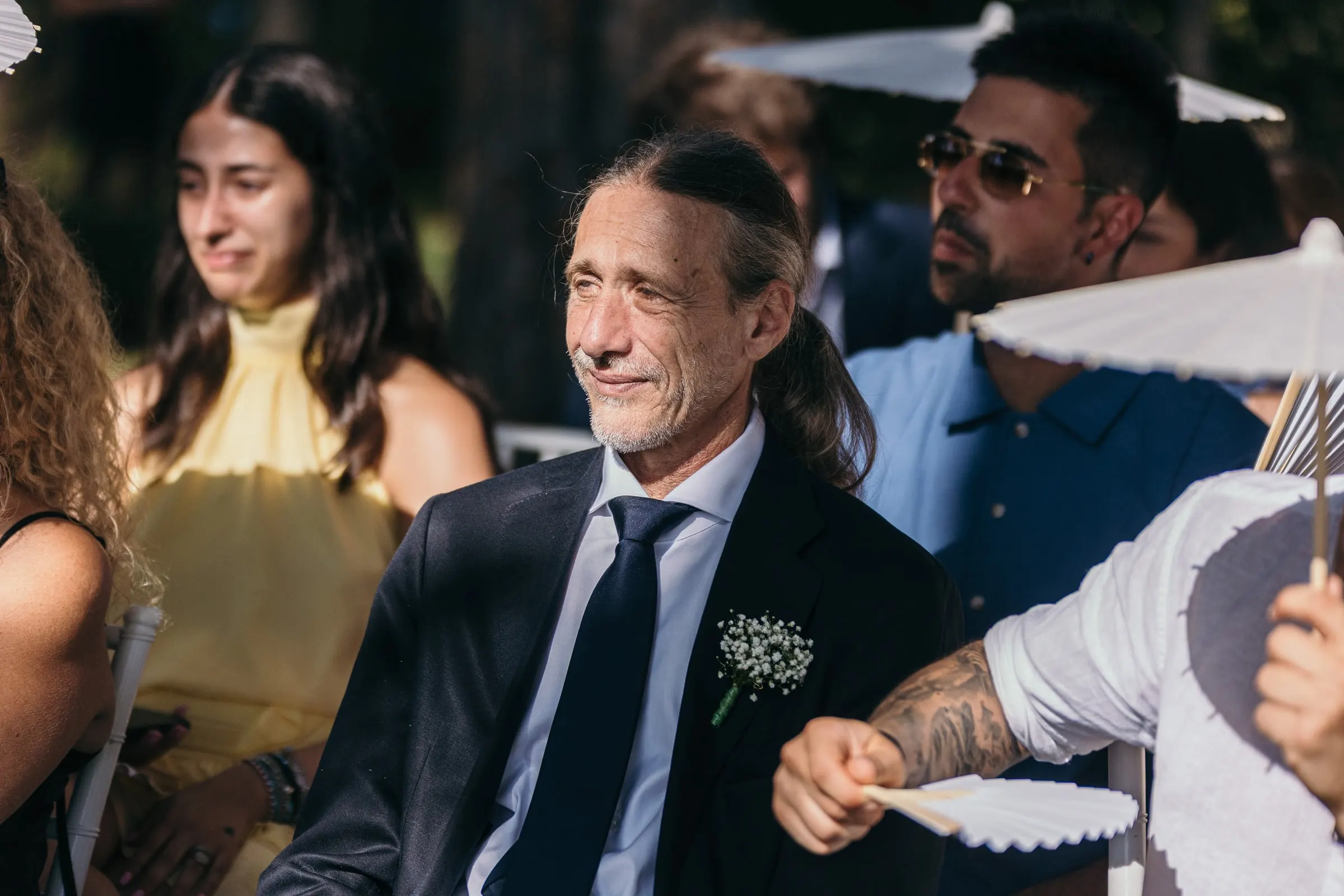 Un invitado se ríe durante los votos mientras otros se abanican