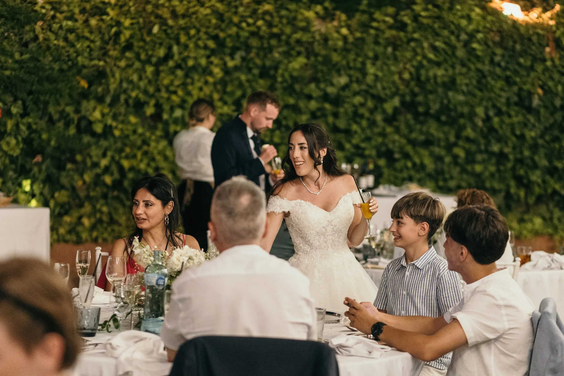 Los novios se paran a hablar con los invitados en su mesa durante la cena