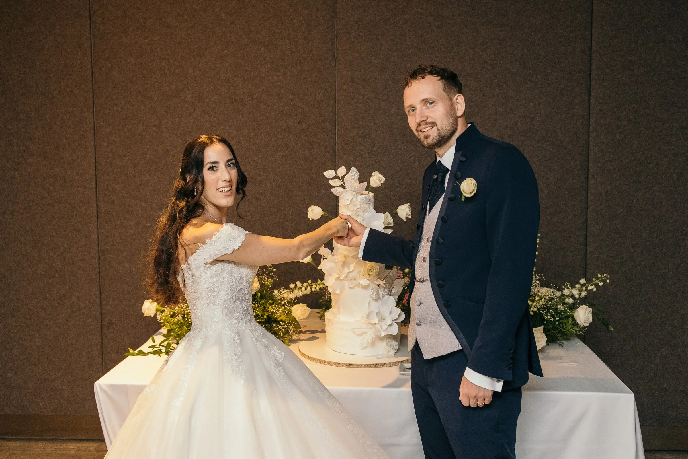 Sara y Vincent cortan su tarta blanca decorada con flores