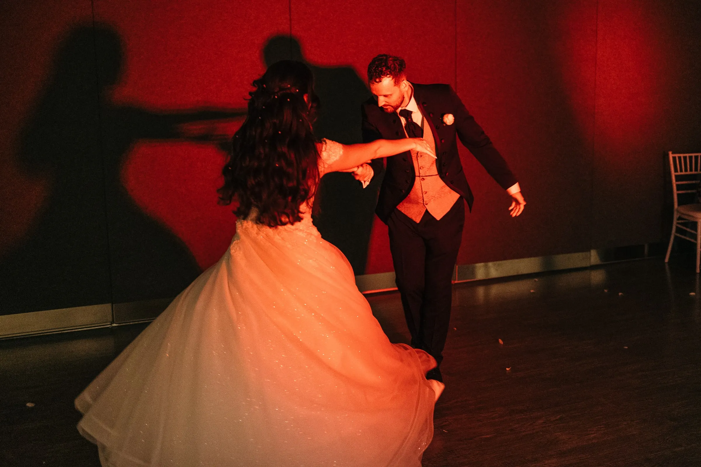 Sara y Vincent bailan bajo la luz roja, con sus sombras en la pared