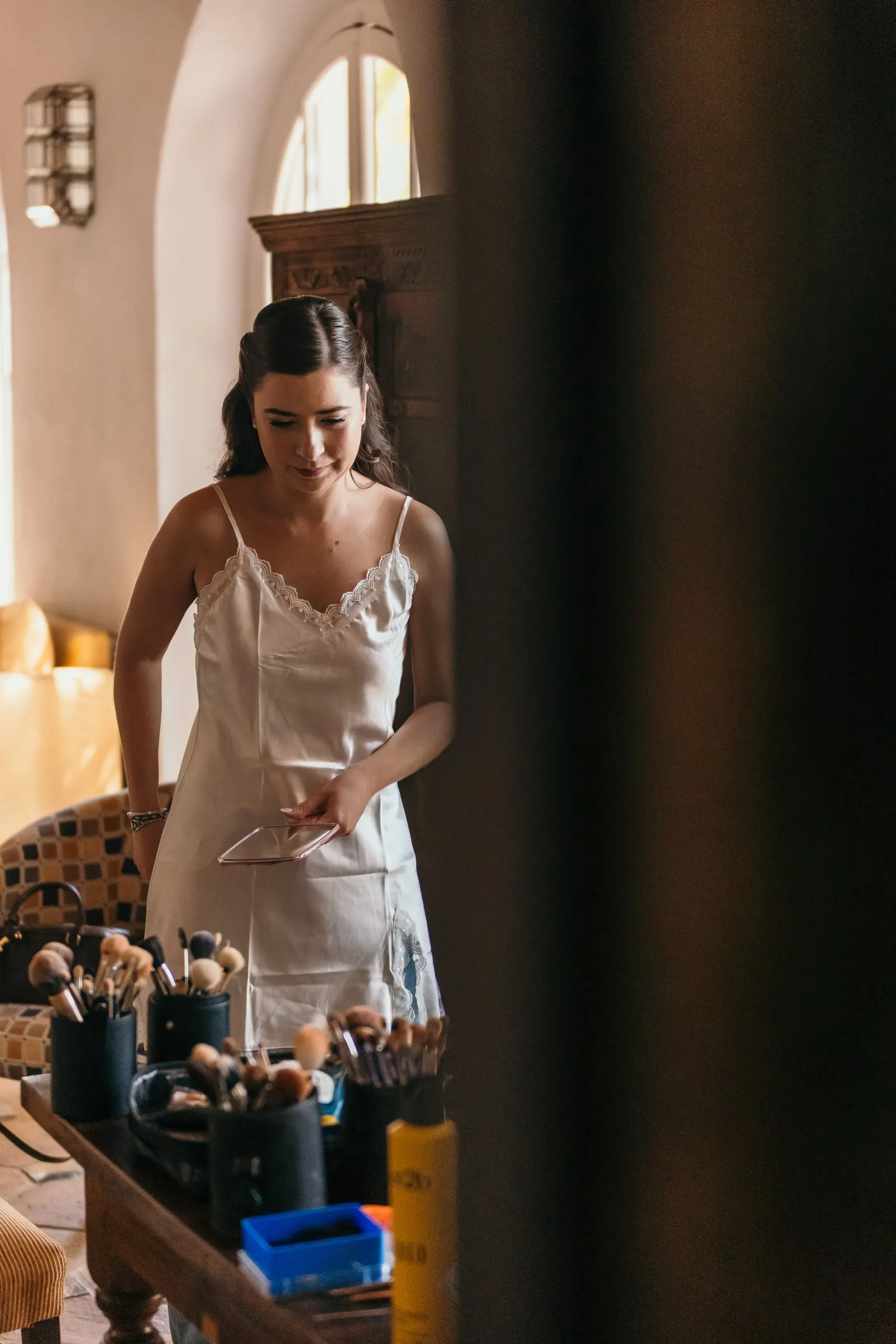 Bride in her slip by the make-up table while getting ready, Cortijo San Francisco, Estepona