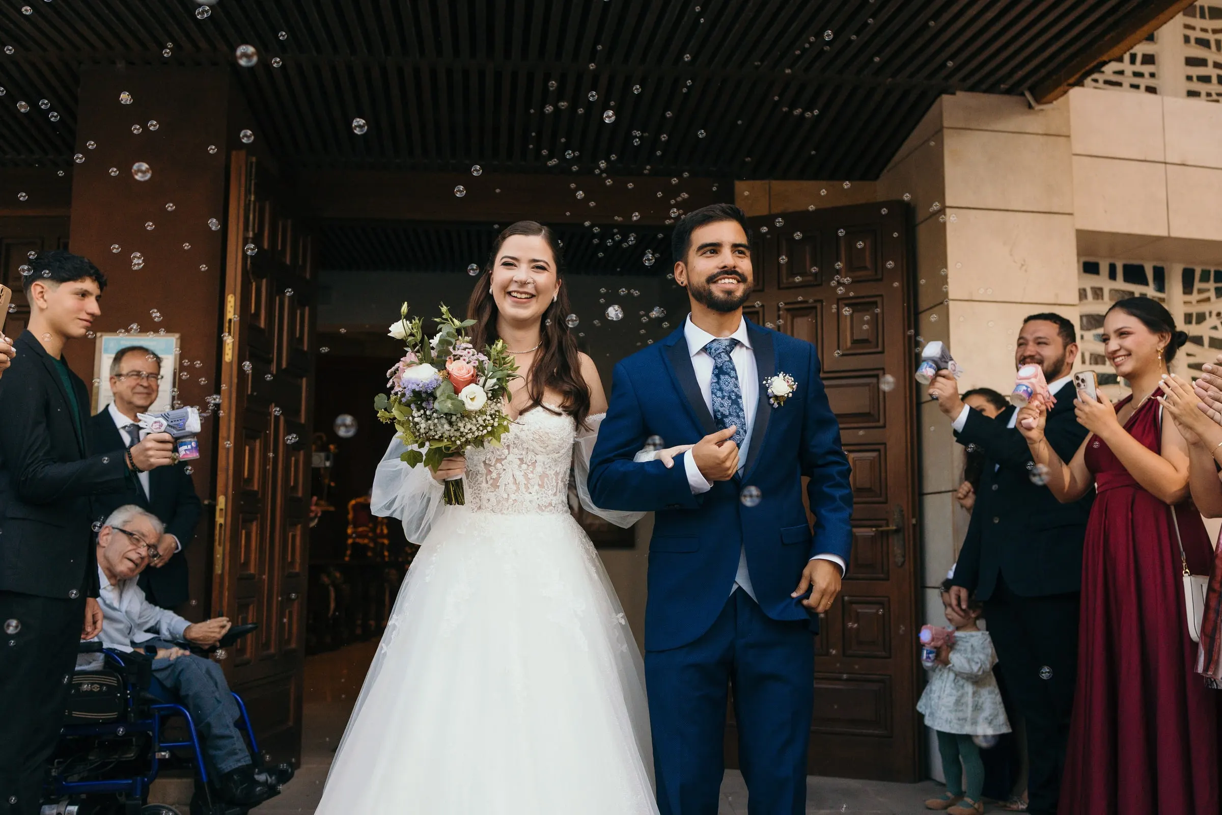 Los novios salen por una puerta de madera entre aplausos y pompas de jabón, Cortijo San Francisco, Estepona