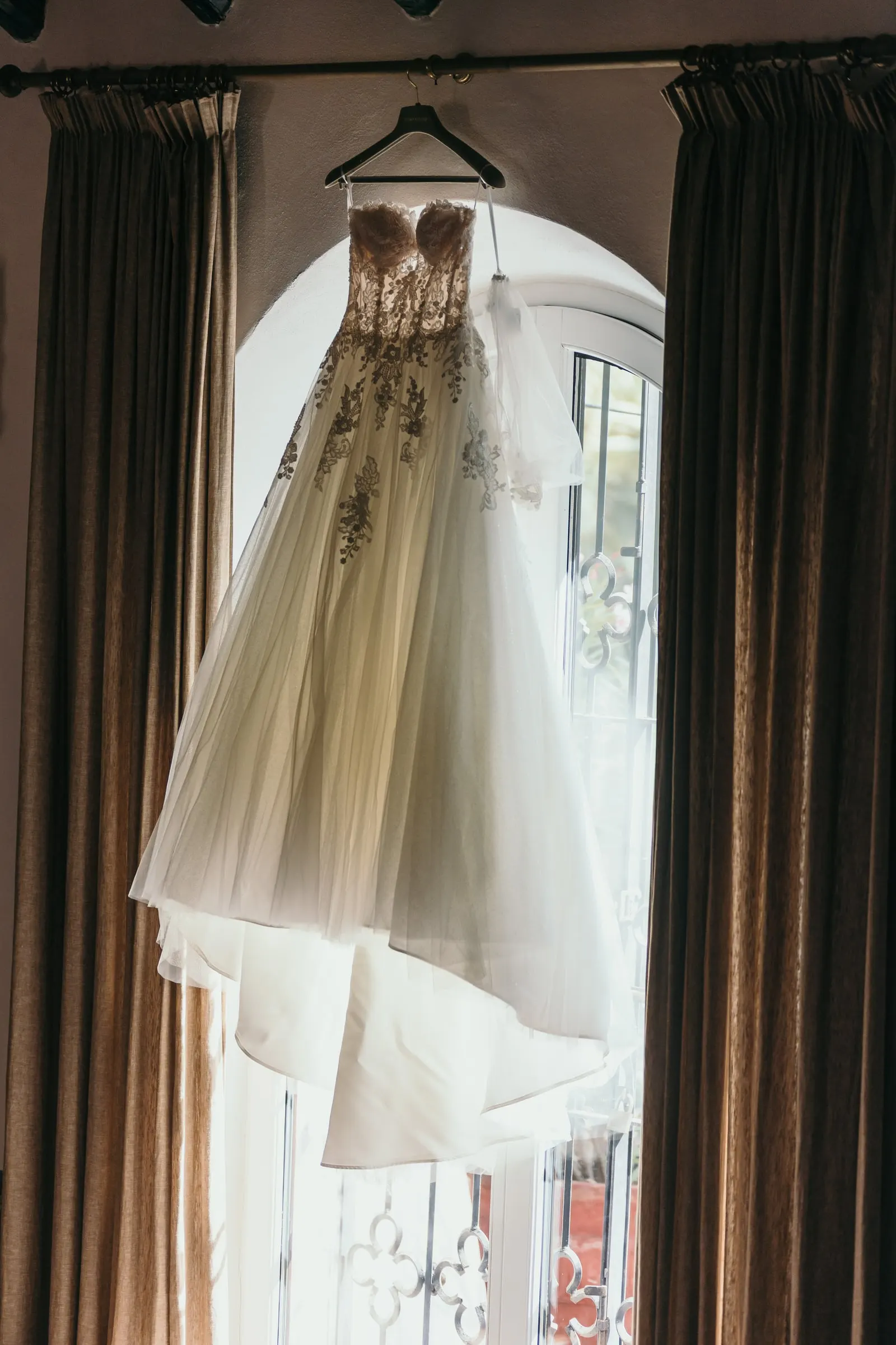 El vestido de novia bordado, en la percha, a contraluz de la ventana, Cortijo San Francisco, Estepona