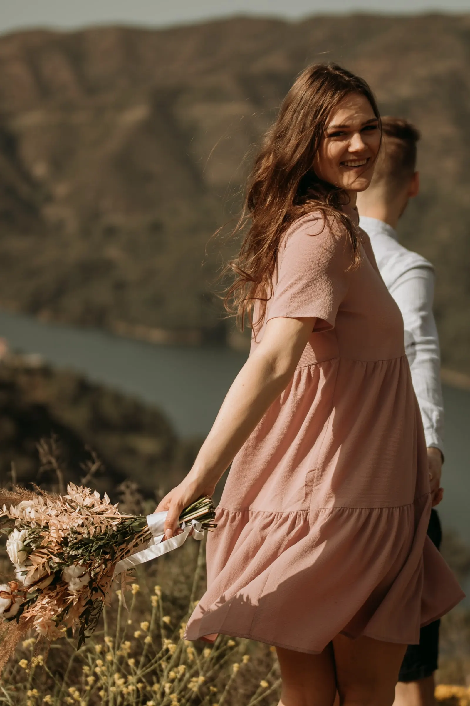 Bride-to-be laughing as she spins away with her bouquet