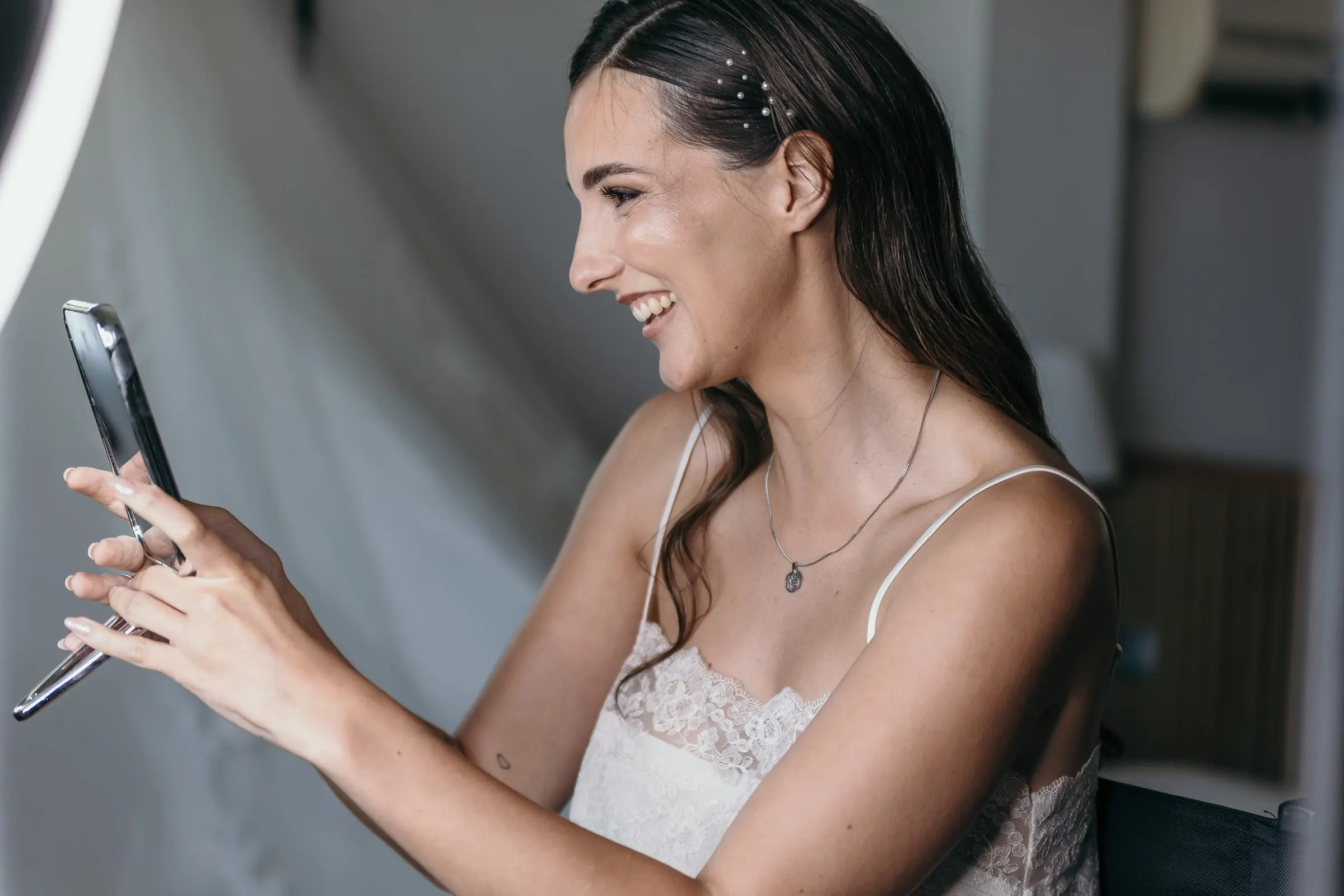 La novia se ríe al verse en la pantalla del móvil junto al aro de luz
