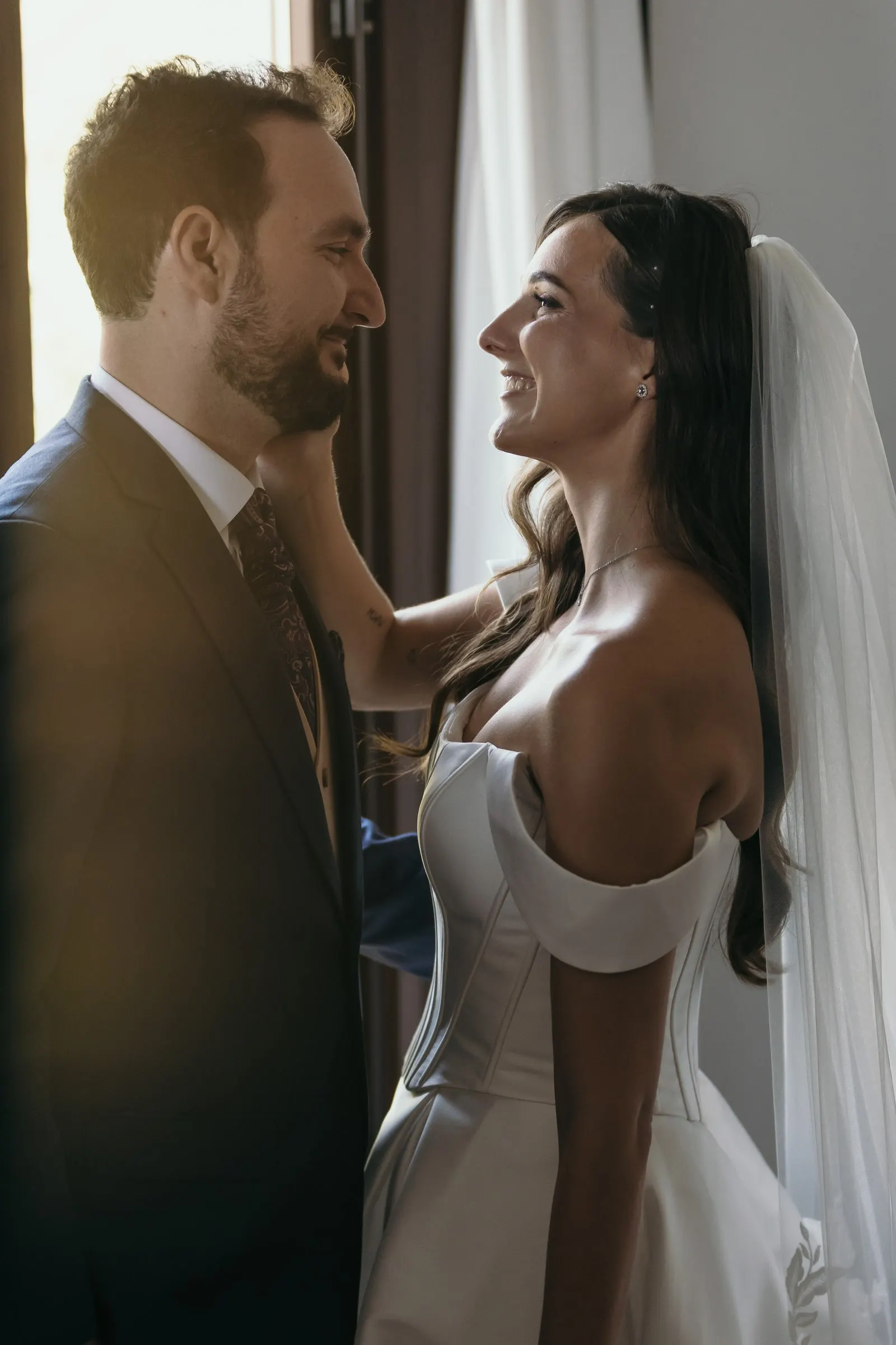 Bride touching the groom's cheek as they laugh together