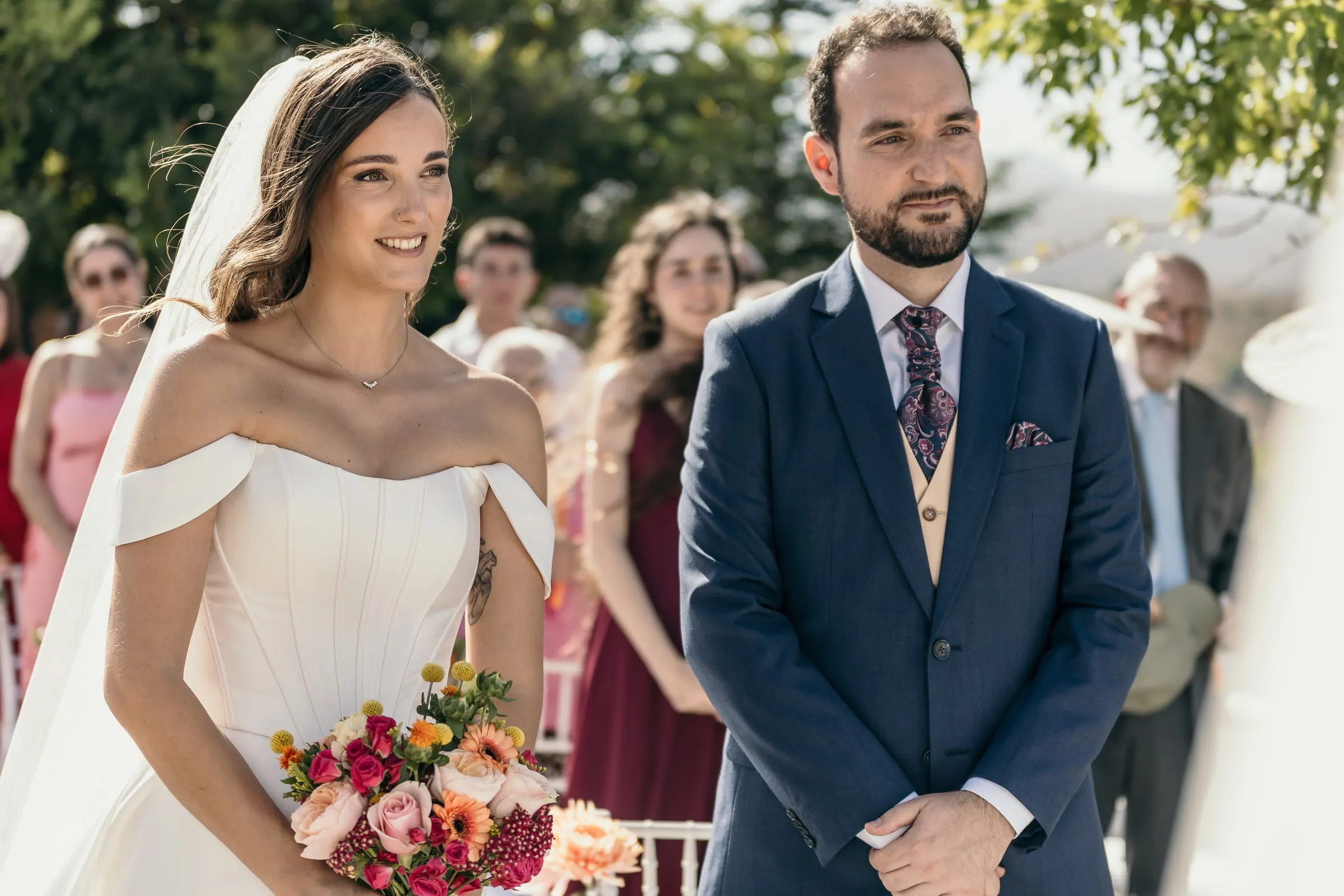 Bride and groom standing side by side as their outdoor ceremony begins