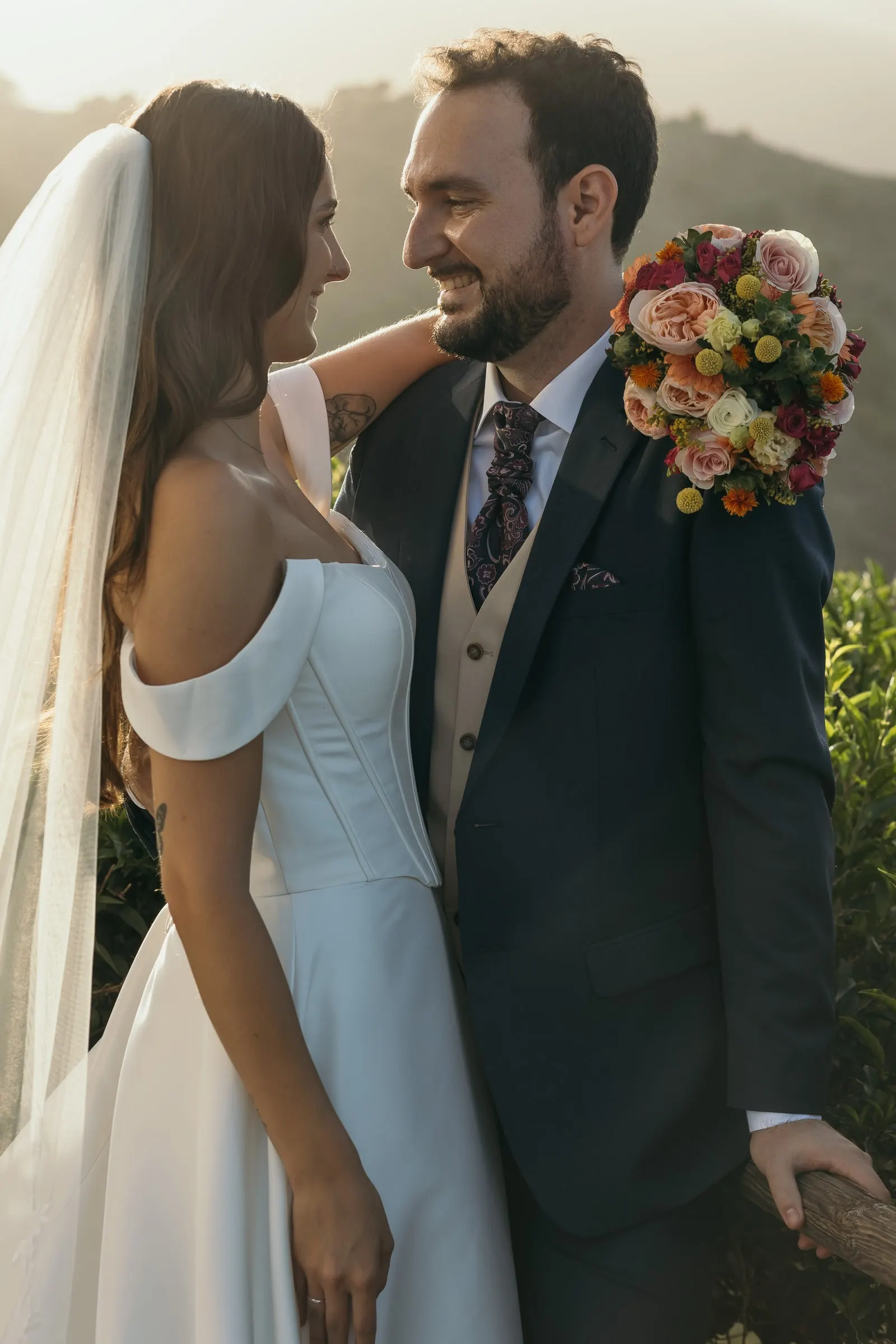 Bride and groom laughing together in golden evening light