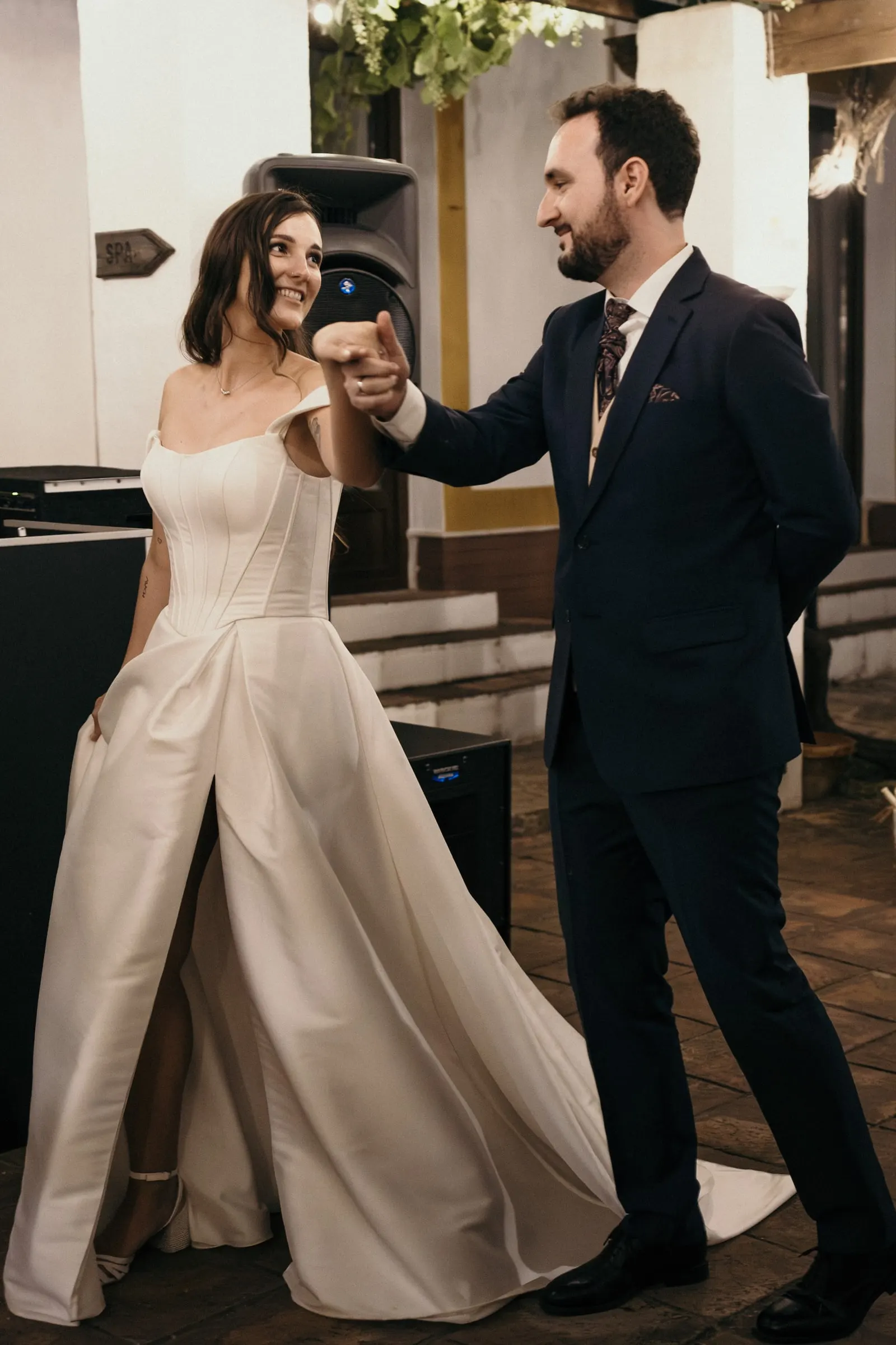 Groom reaching for the bride's hand as their first dance begins on the terrace