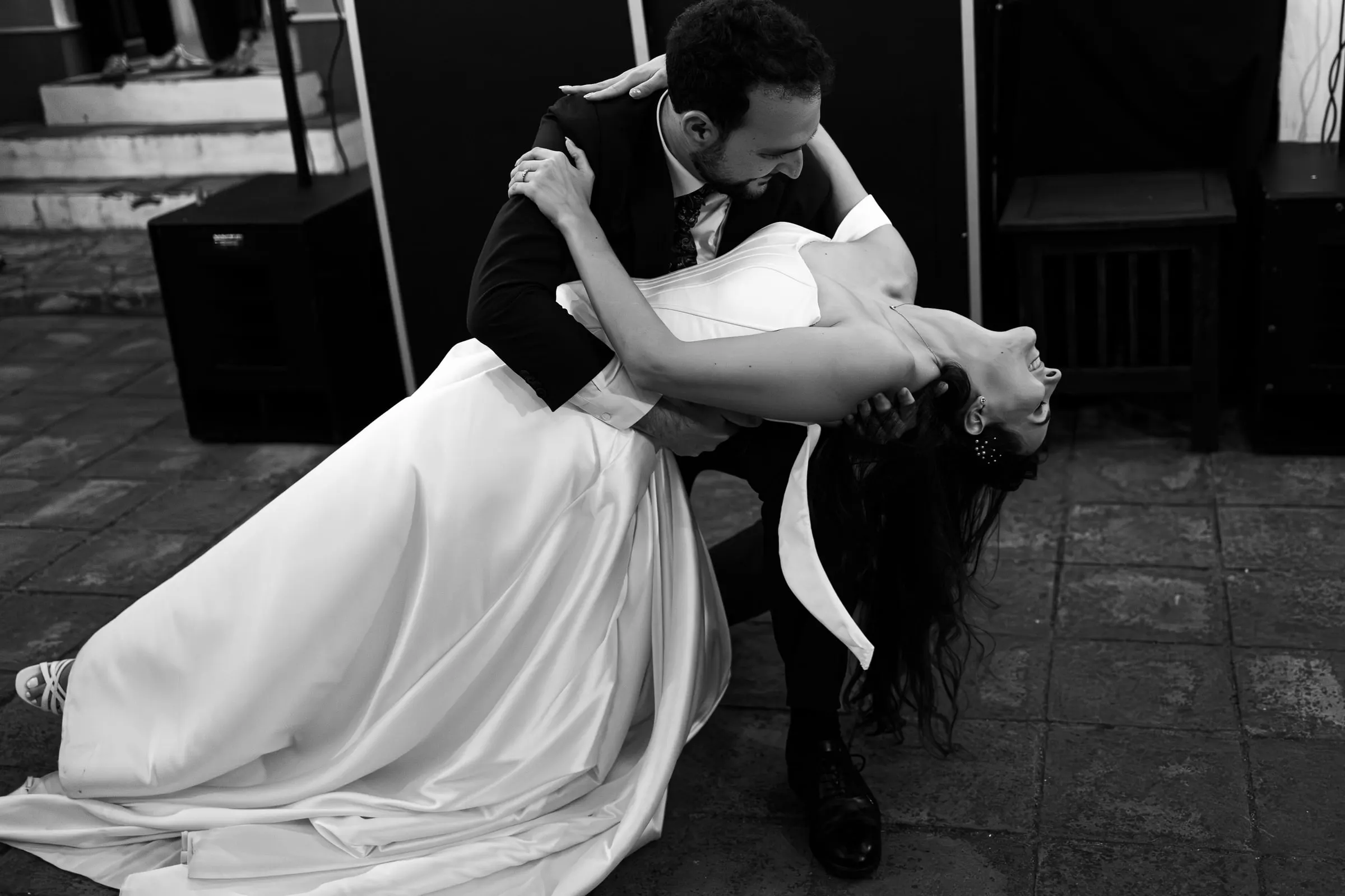 Black and white of the groom dipping the bride low at the end of the first dance