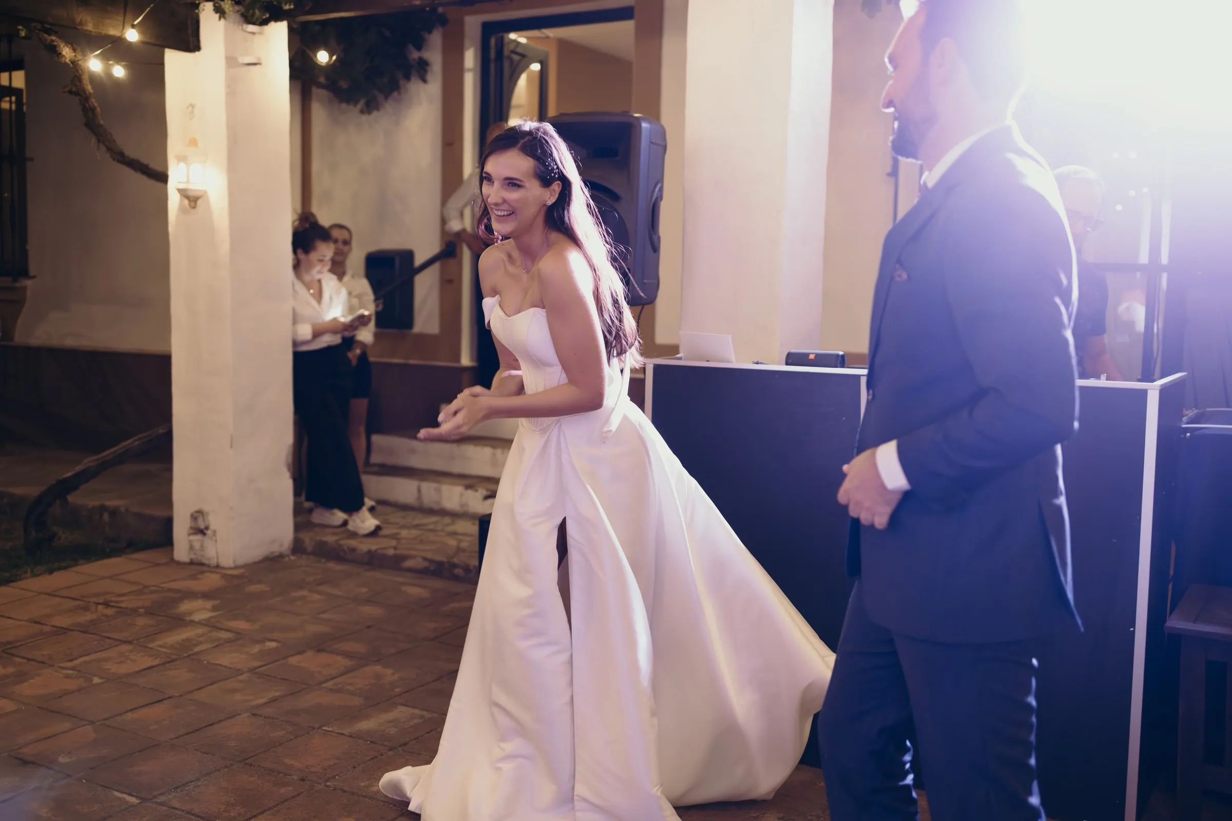 Bride laughing on the dance floor in a wash of purple light