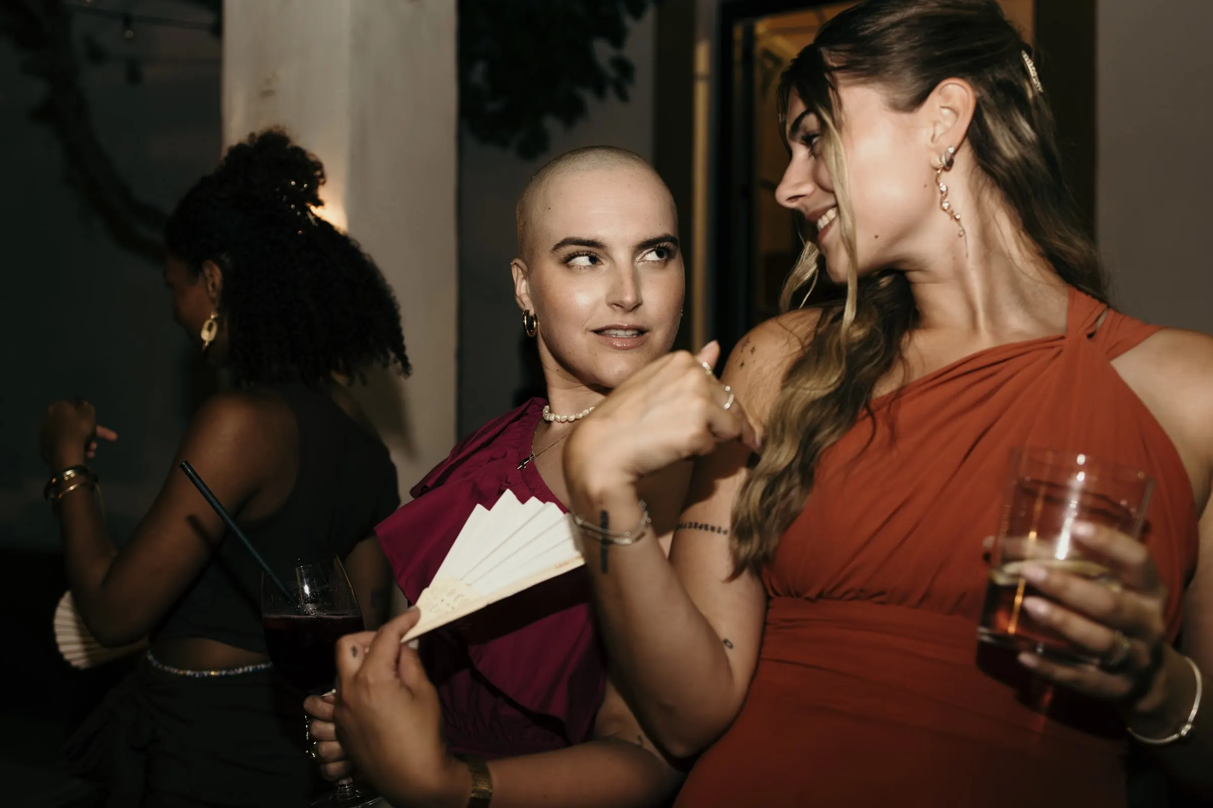 Two friends dancing on the porch with a fan and a glass