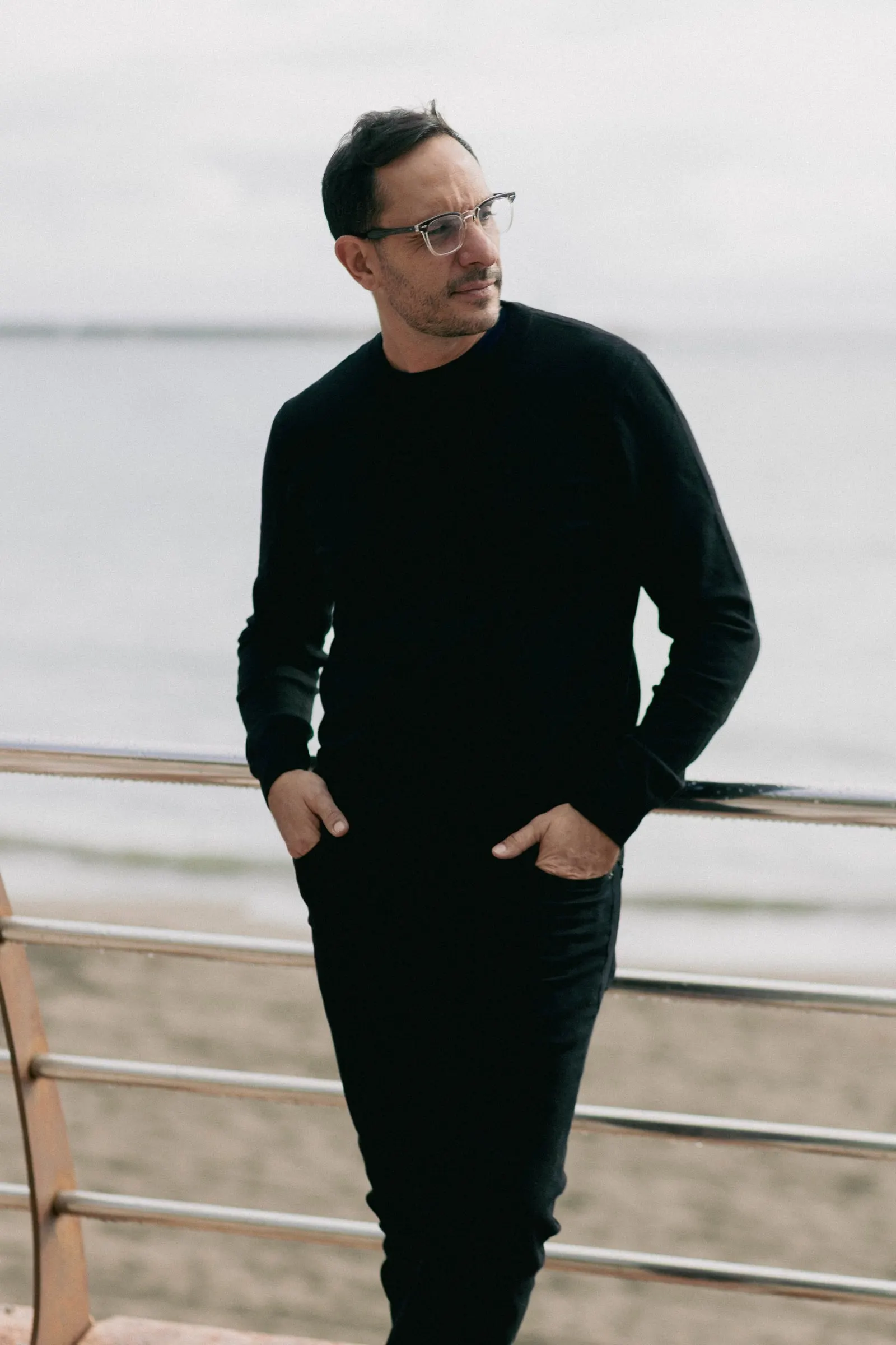 Diego, fotógrafo de Picart, con jersey negro, apoyado en la barandilla del paseo marítimo, Estepona