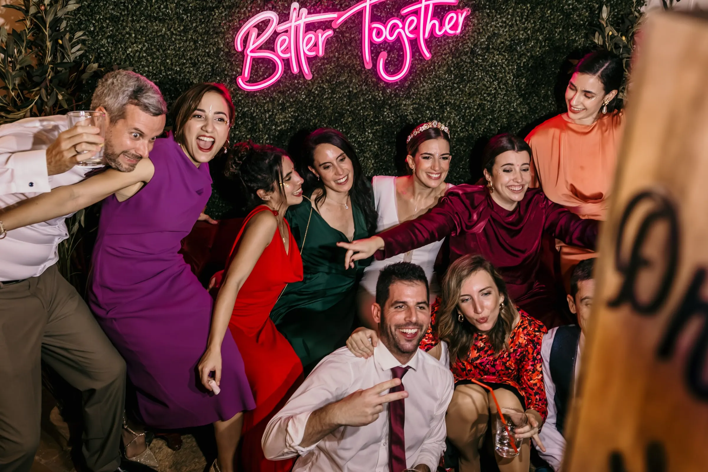Guests laughing and posing under a pink 'Better Together' neon sign at the party, Finca Espanta Rodrigo, Jerez de la Frontera