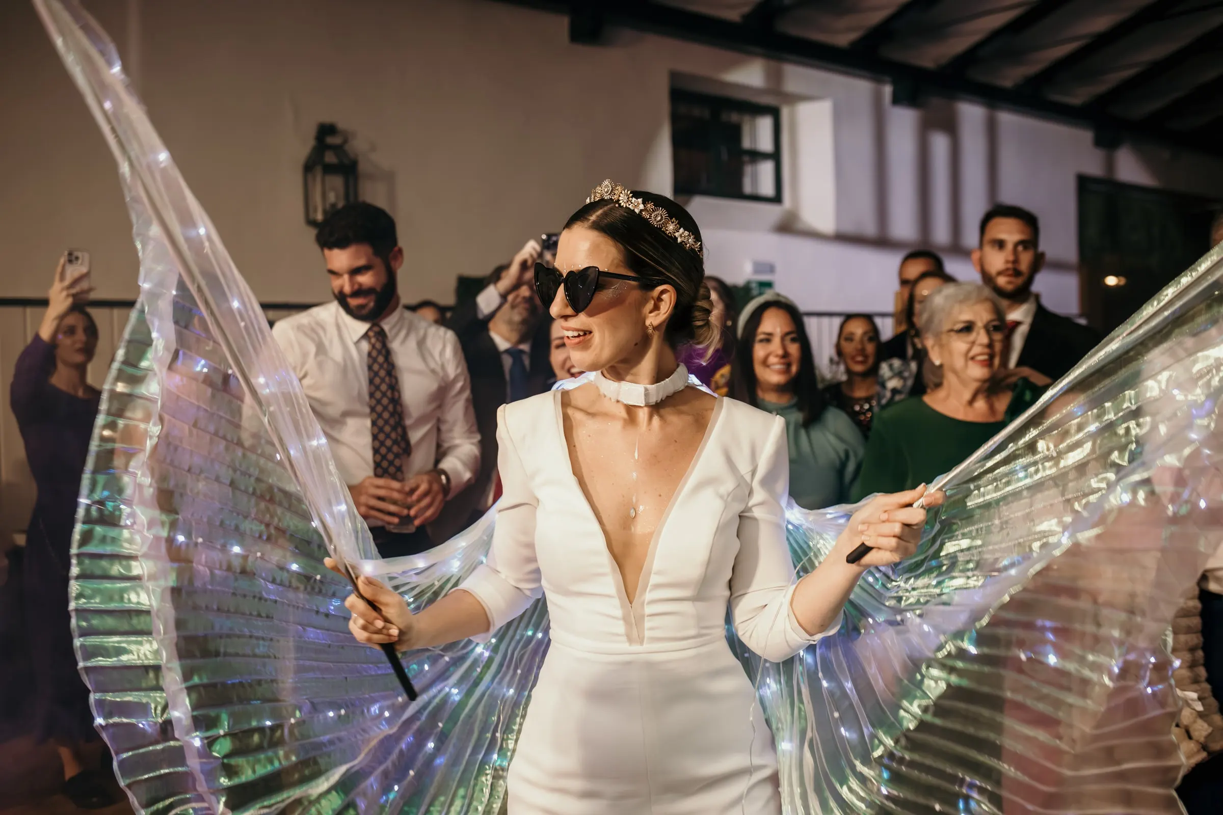 Bride dancing in heart sunglasses and glowing wings at night, Finca Espanta Rodrigo, Jerez de la Frontera