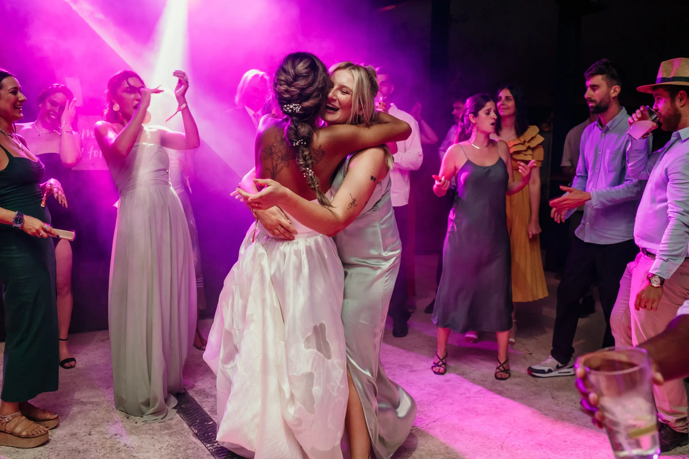 La novia abraza a una amiga en mitad de la pista