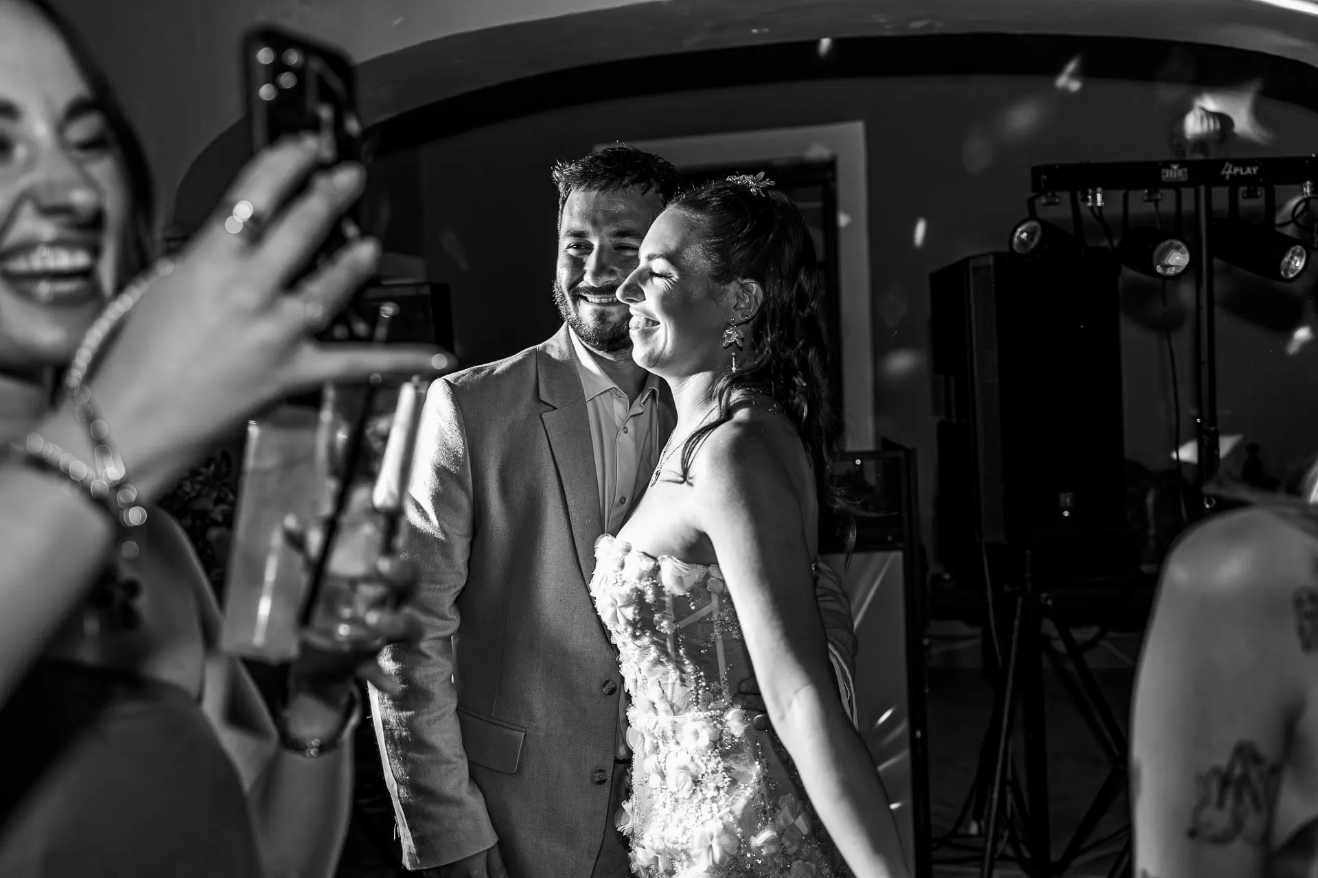 Black and white of guests filming on their phones as the bride and groom enter the party, Hacienda San José, Mijas