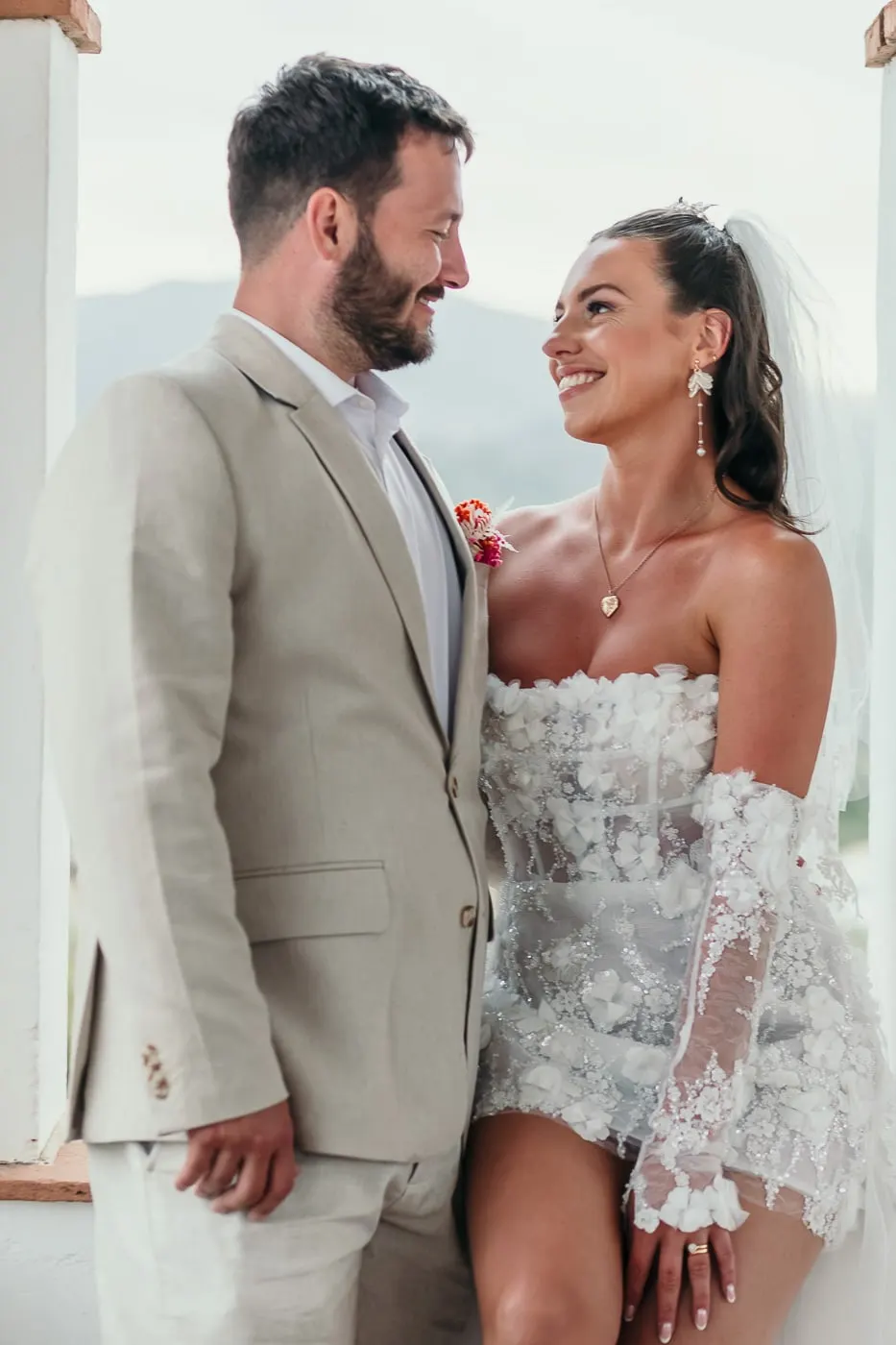 Bride and groom smiling at each other on a white terrace with mountains behind, Hacienda San José, Mijas