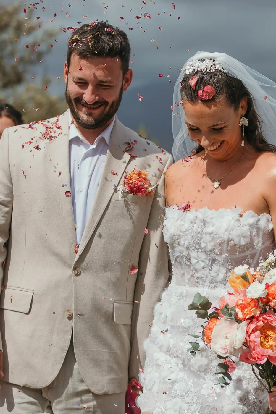 Bride and groom laughing under a shower of pink petals after the ceremony, Hacienda San José, Mijas