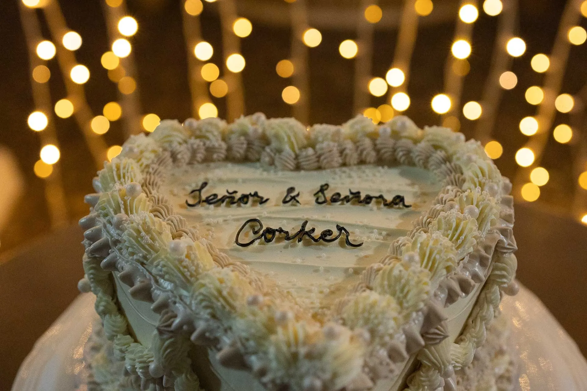 Heart-shaped piped wedding cake reading 'Señor & Señora' under fairy lights, Hacienda San José, Mijas