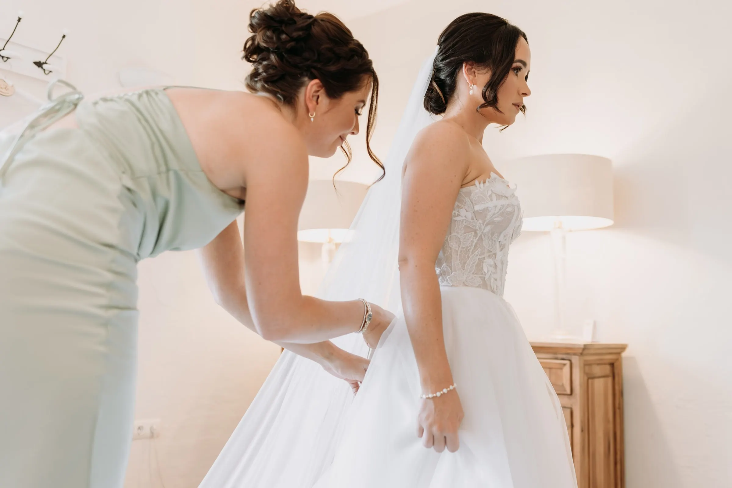 Bridesmaid lacing the back of the strapless wedding dress, Hacienda San José