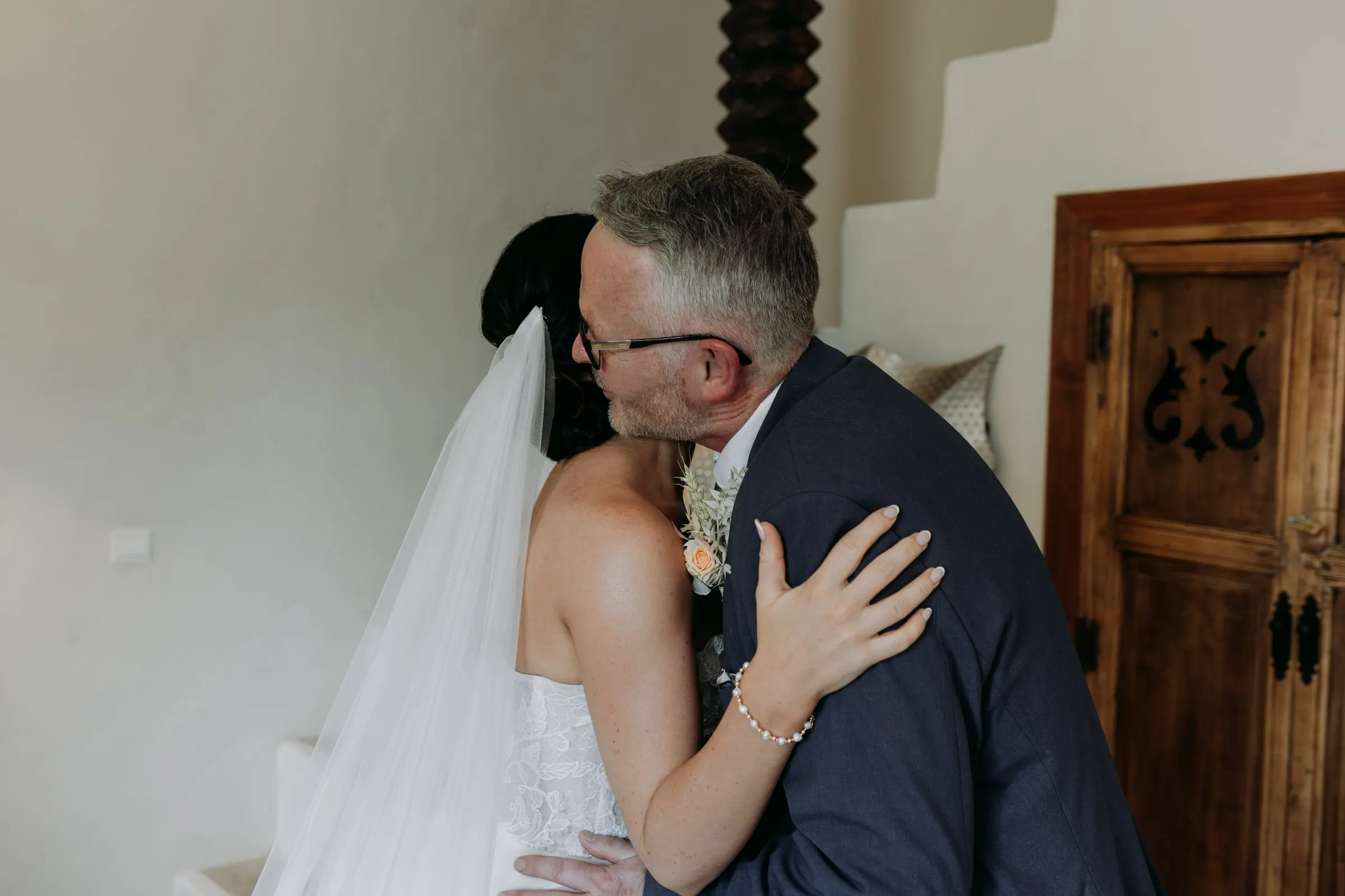 Bride hugging her father at the foot of the stairs, Mijas