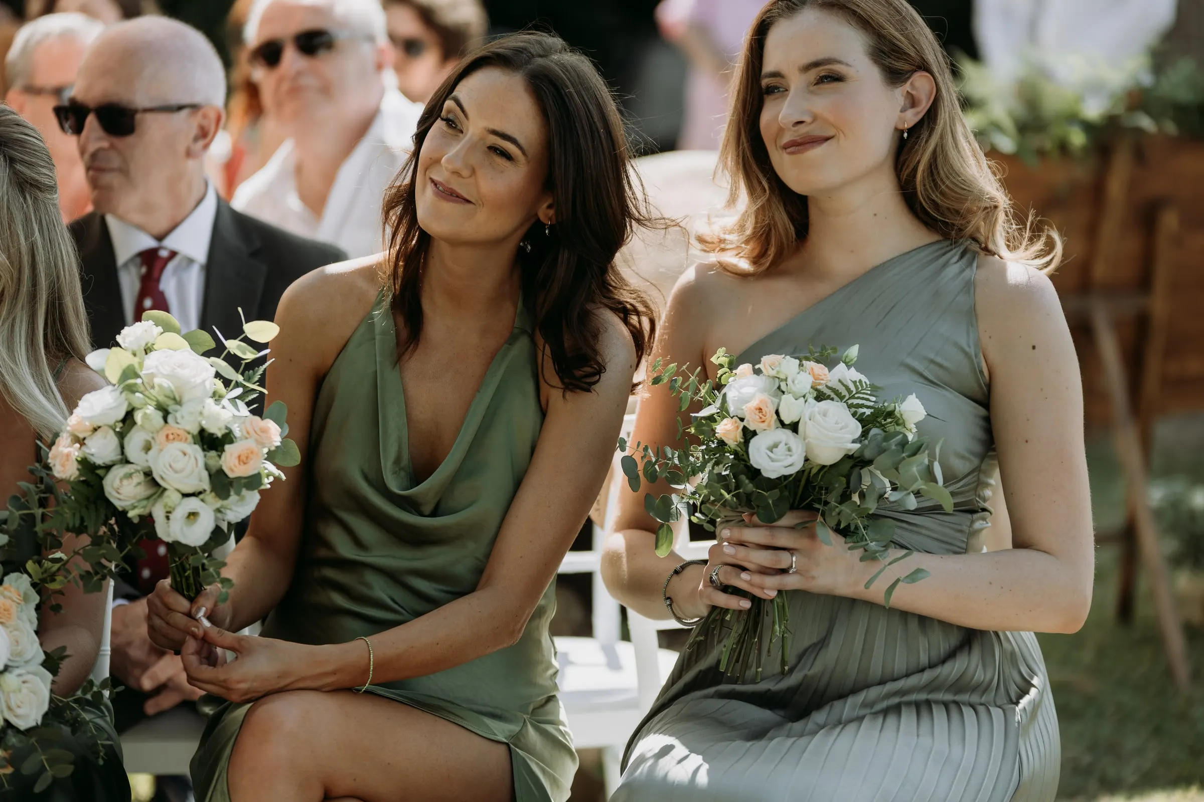 Two bridesmaids in sage green smiling in the front row, Mijas