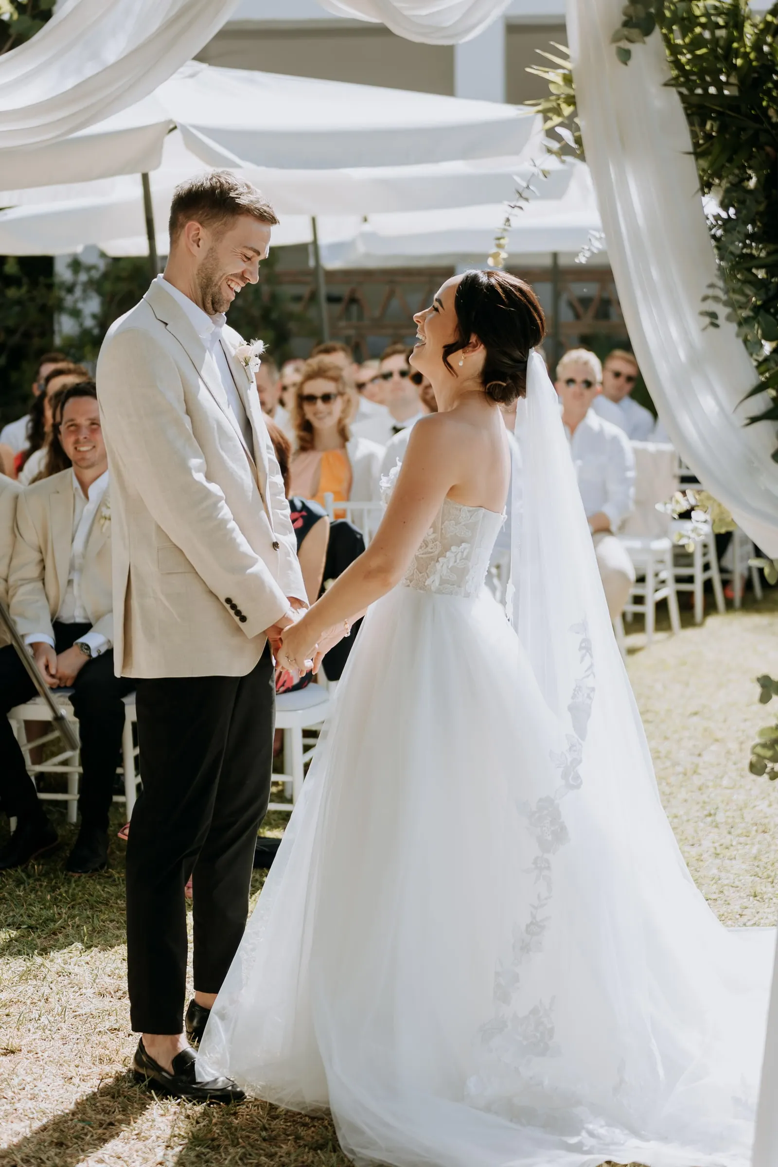 Bride and groom holding hands at the front of the garden ceremony, Mijas