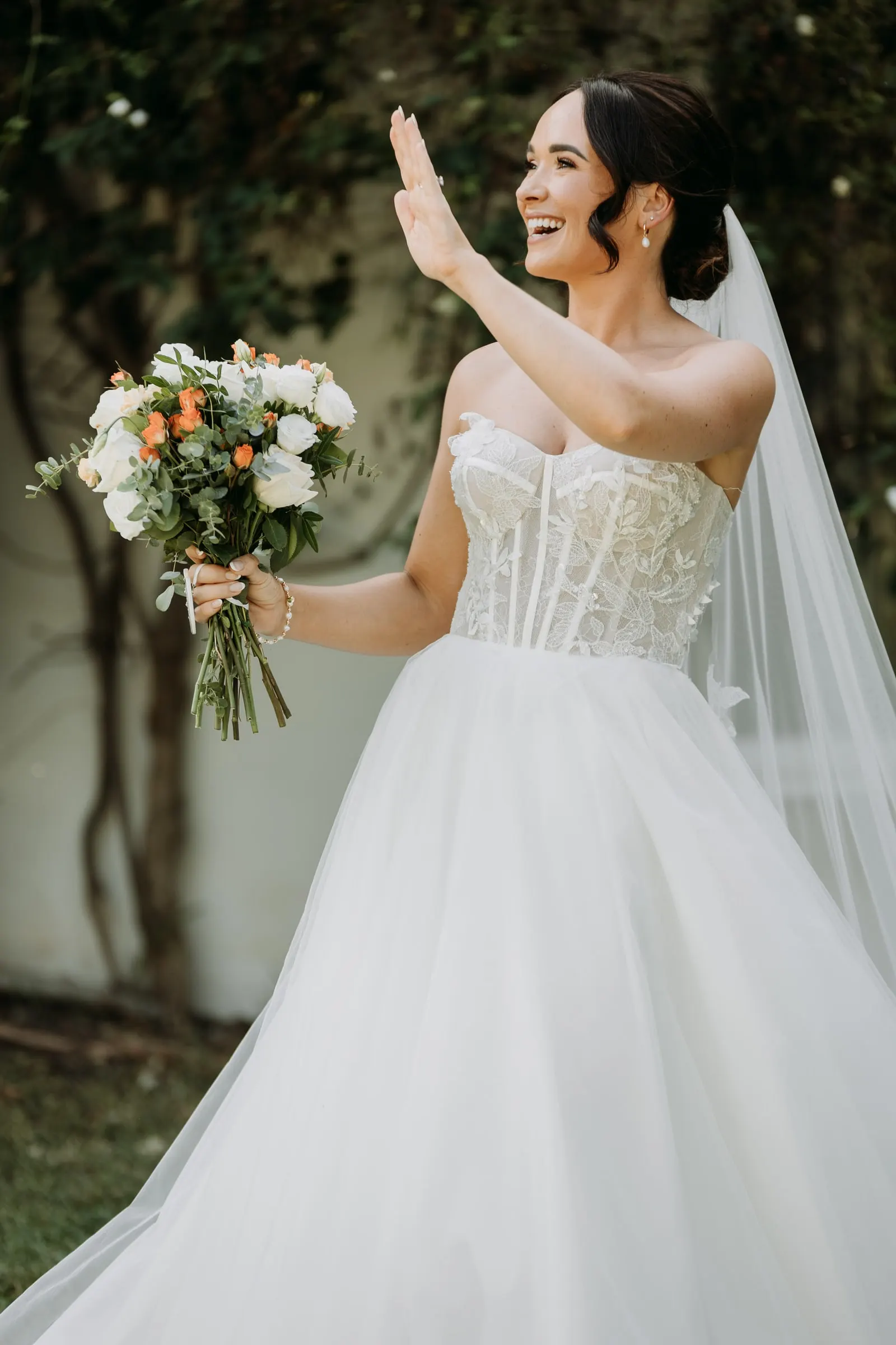 Bride waving her bouquet in the garden after the ceremony, Mijas