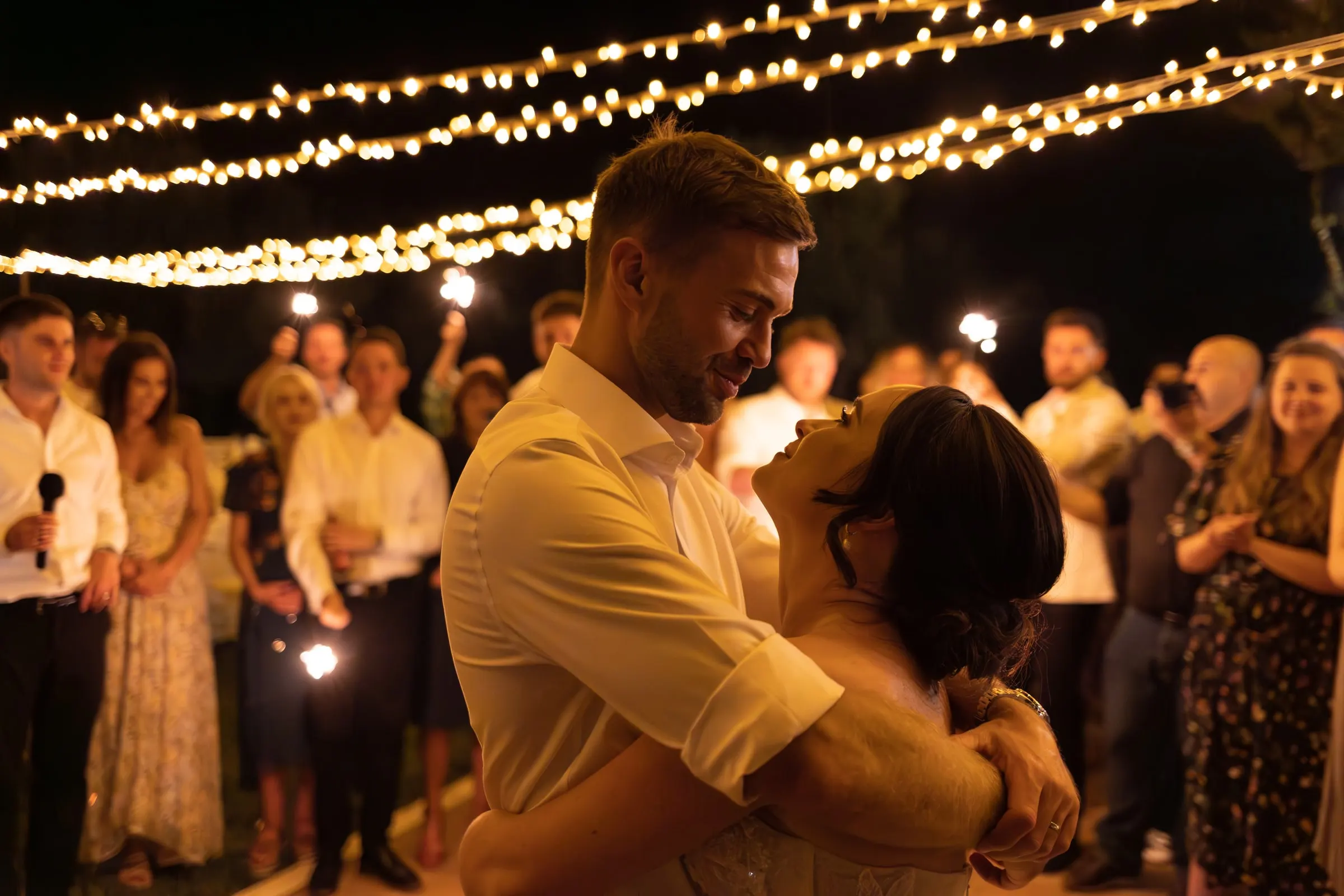 First dance under the strings of lights, guests holding sparklers all around, Mijas