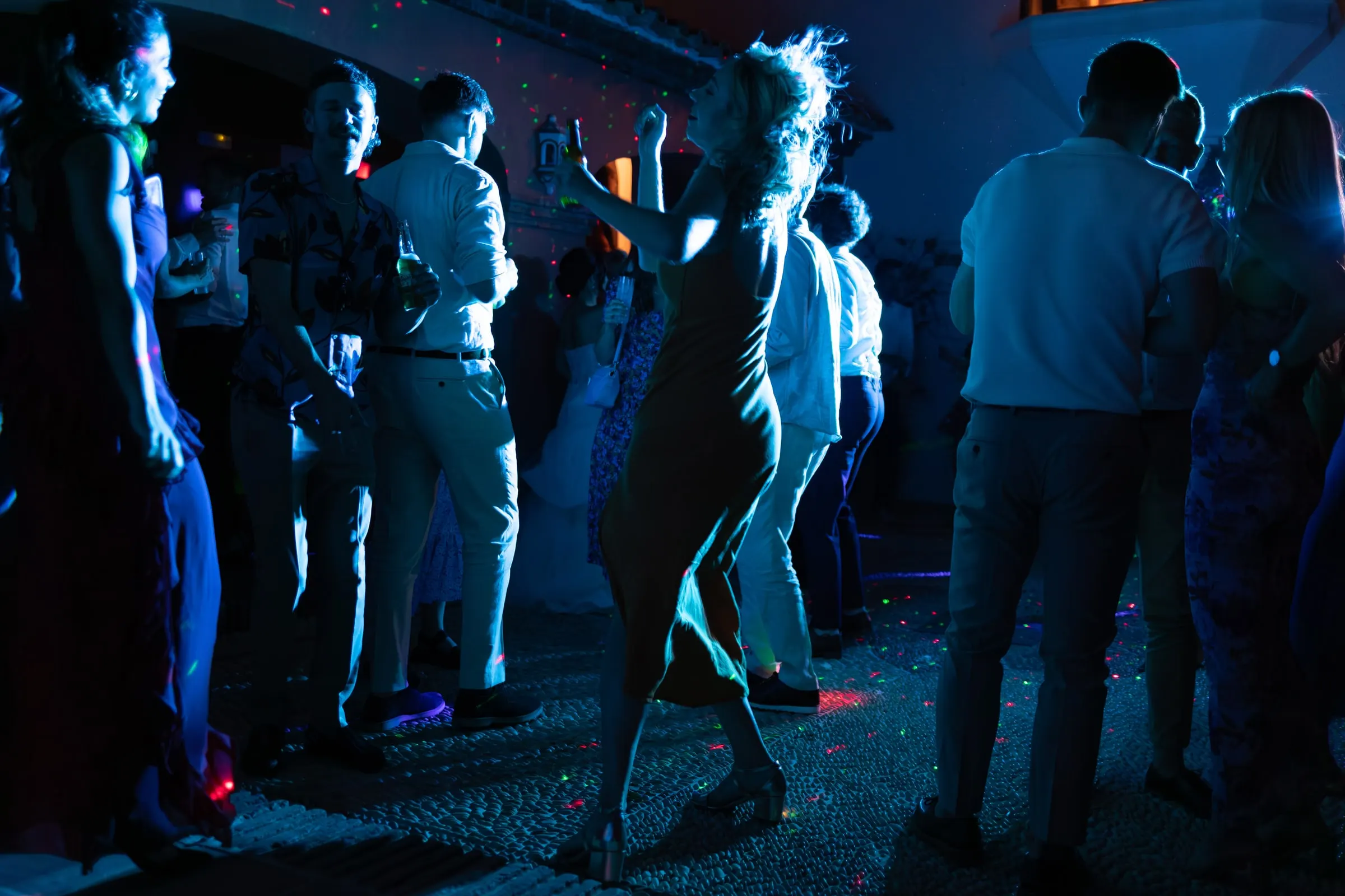 Guests dancing in blue light at the party, Hacienda San José