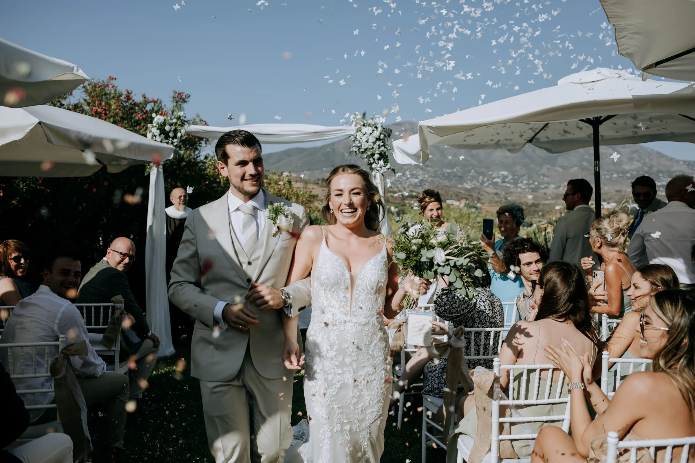 Los novios salen por el pasillo entre confeti mientras los invitados los aclaman, Hacienda San José, Mijas